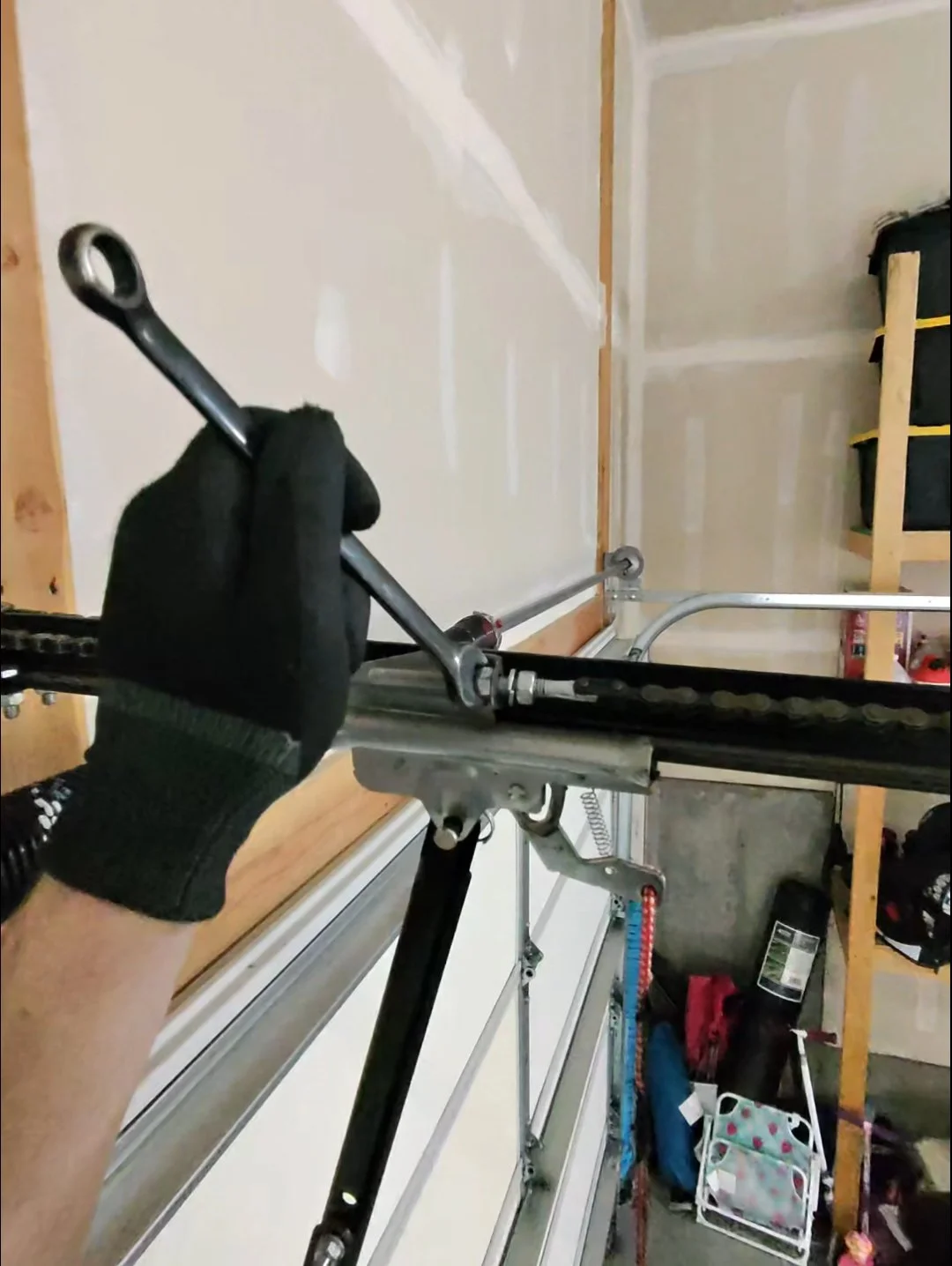 Technician adjusting garage door opener rail during installation