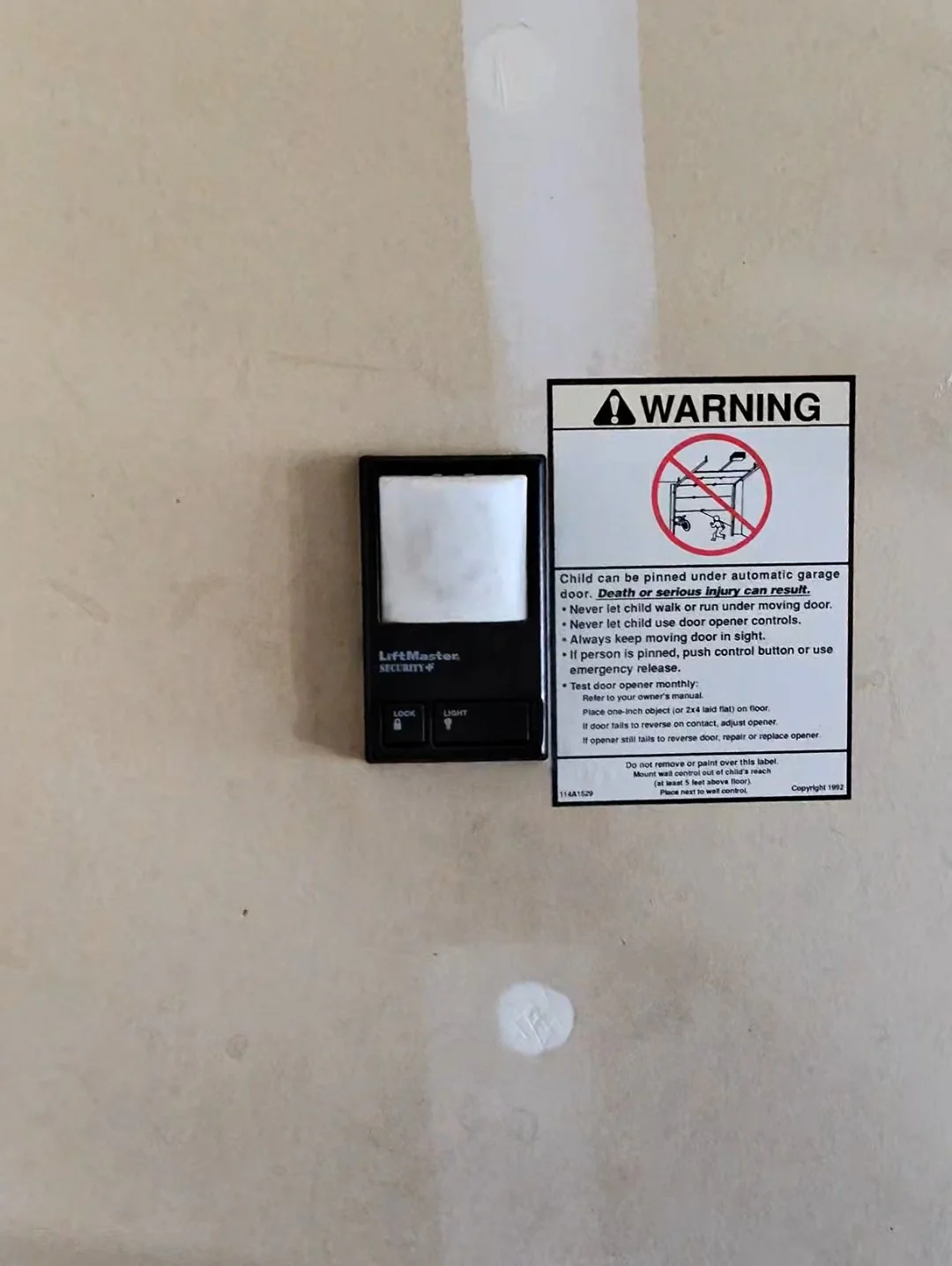 Garage door opener wall control button inside a residential garage