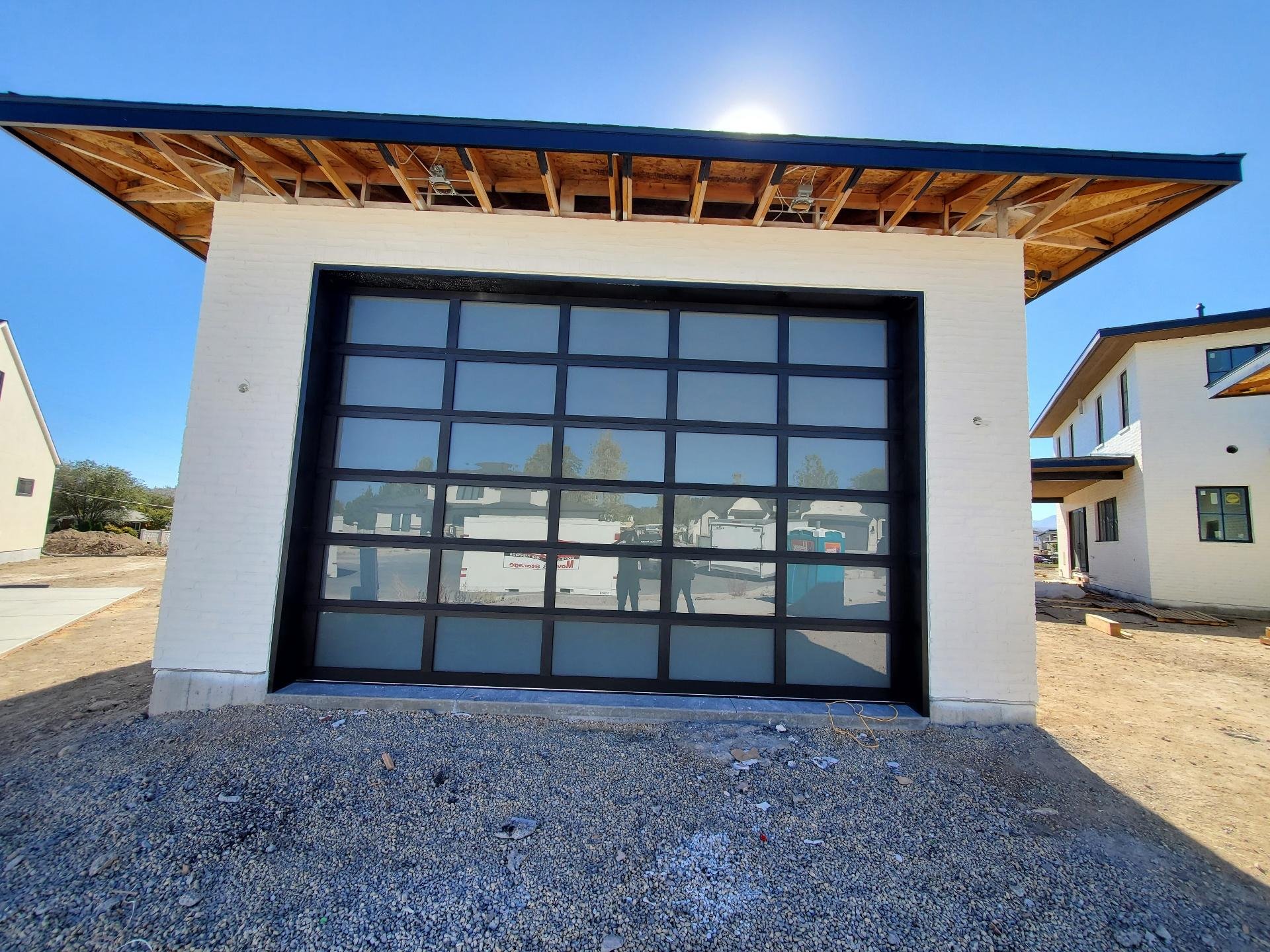 Garage door installation in Utah showing a modern glass garage door on a custom home
