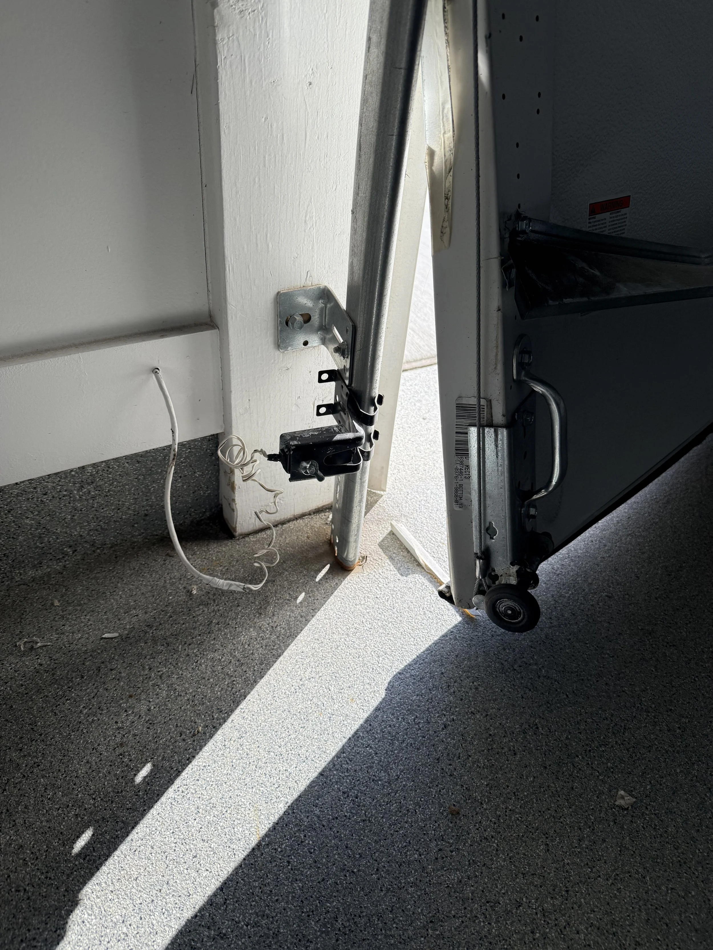 Off-track garage door secured before repair adjustments