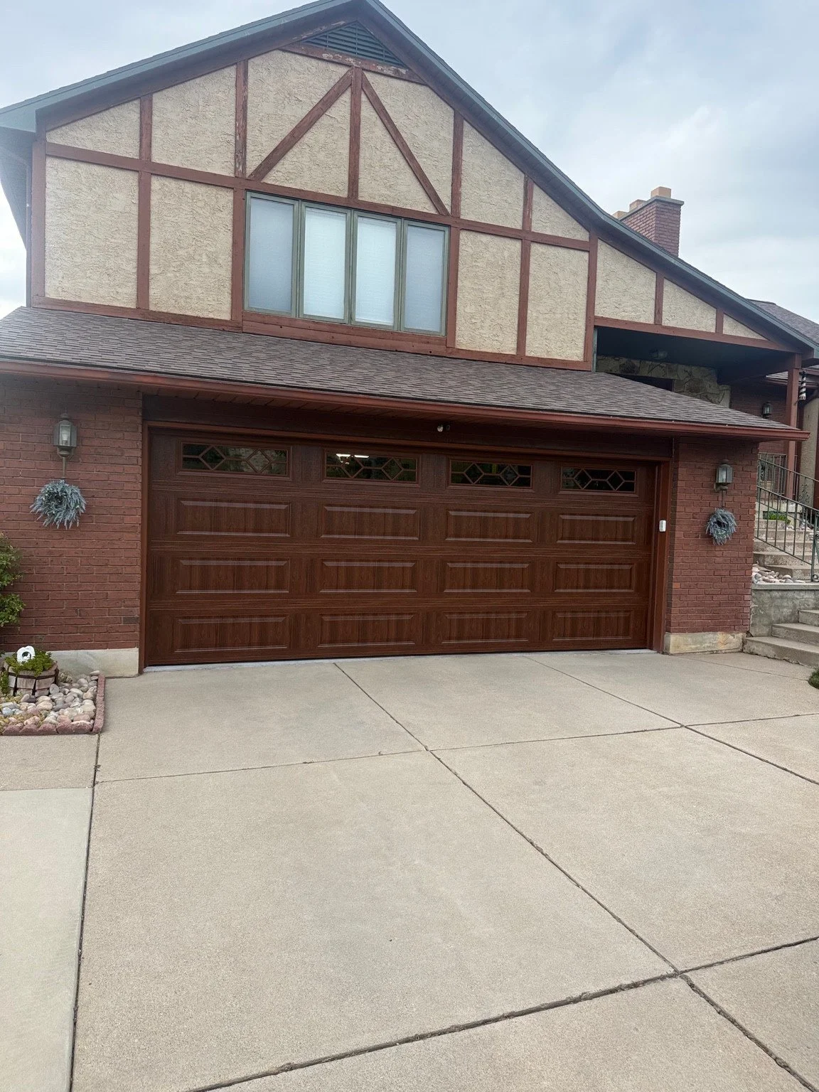 After: the replacement door with a wood-look finish and decorative top windows.