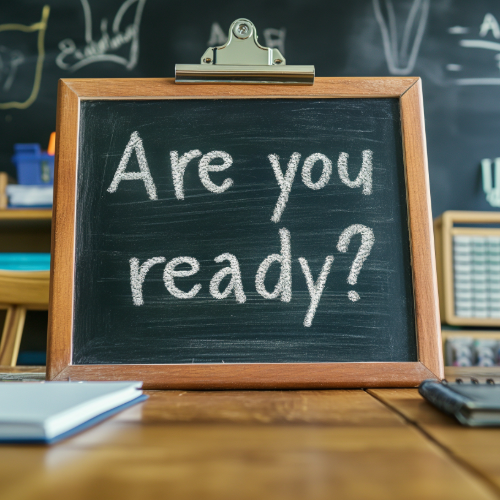 A black chalkboard frame with a clipboard clip at the top has white chalk writing on it which says "Are you ready?".
