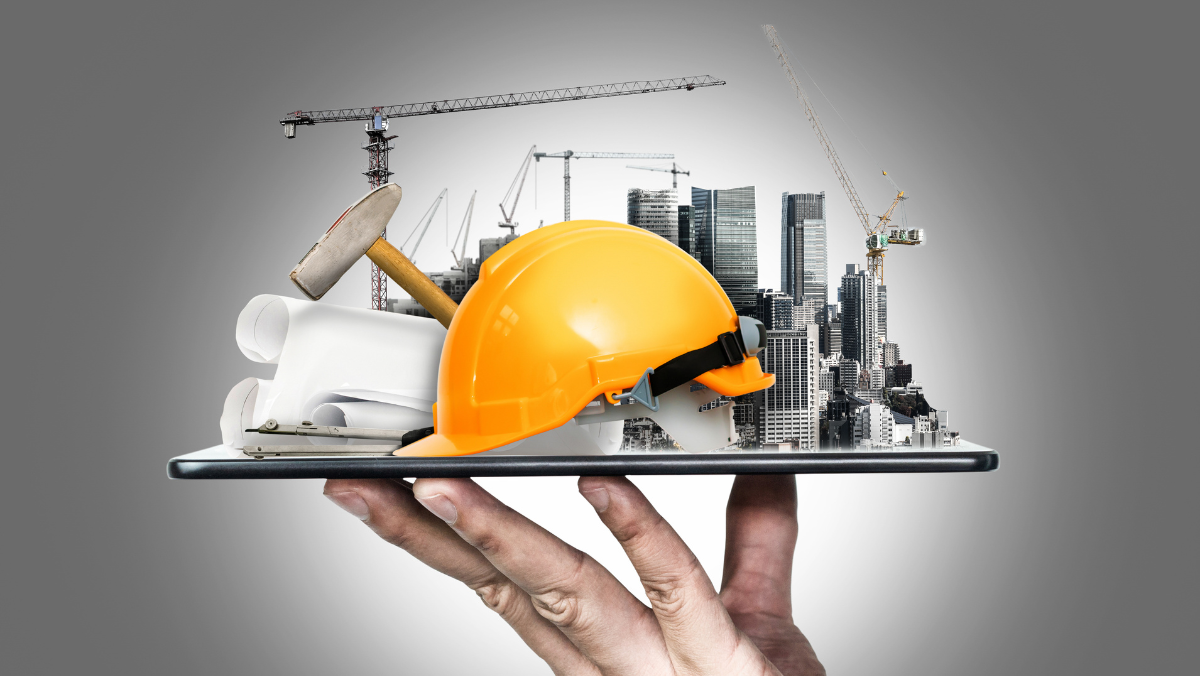 Hand holding a tablet with construction hard hat, blueprint, hammer, and cityscape with cranes emerging from the screen.