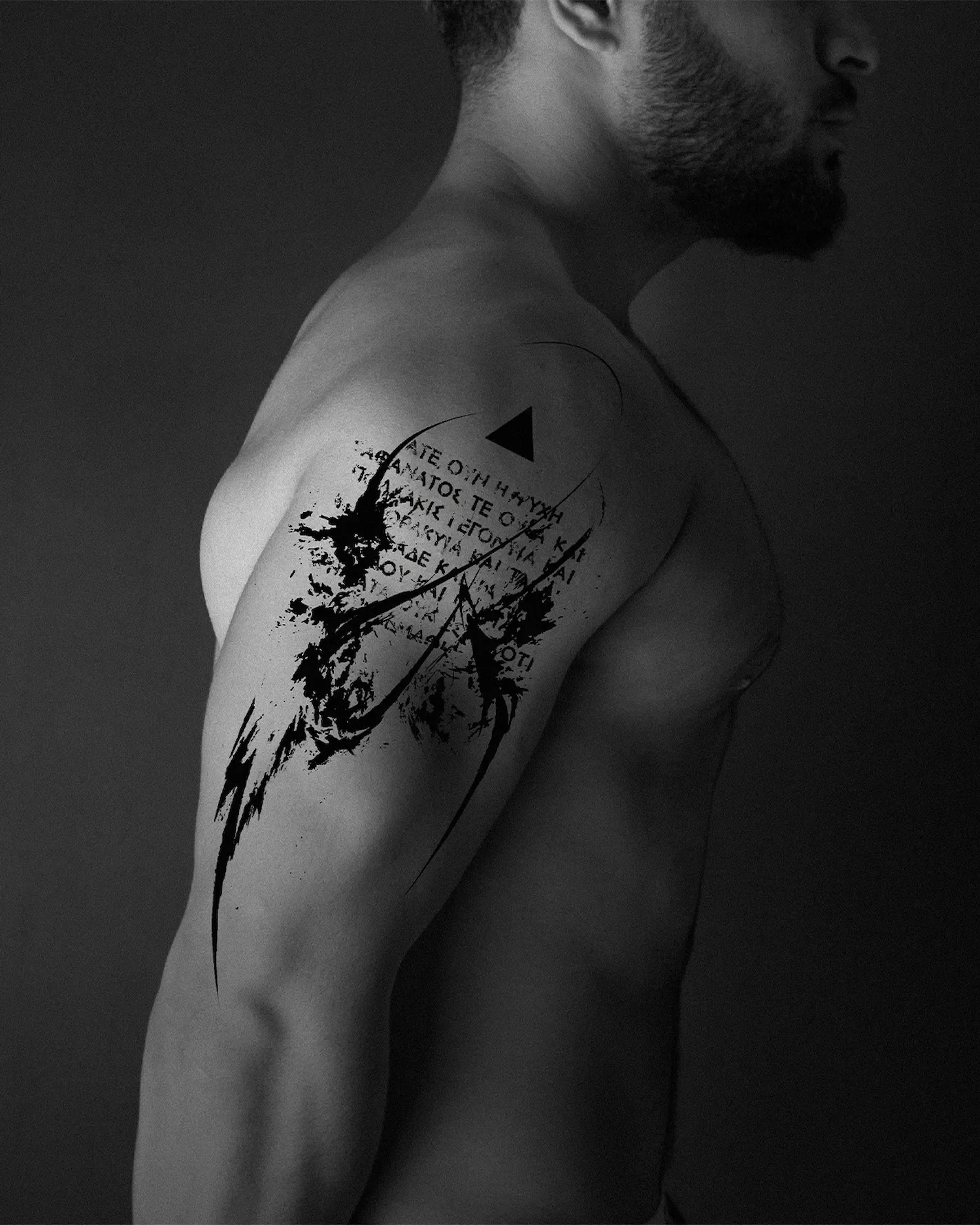 ghost.of.catharsis — Anamnesis concept. Abstract blackwork tattoo on the shoulder with ancient Greek typography and geometric triangle. Philosophical ink art inspired by Plato.