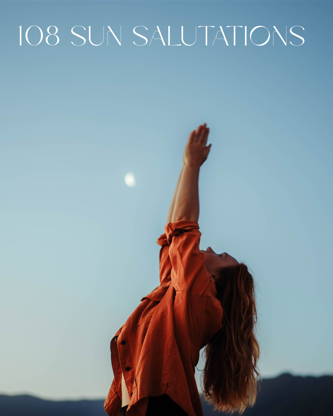 A woman with long red hair dressed in an orange jacket stretching her arms upward outdoors, with a clear sky and the moon visible in the background, over hills at sunset or sunrise.