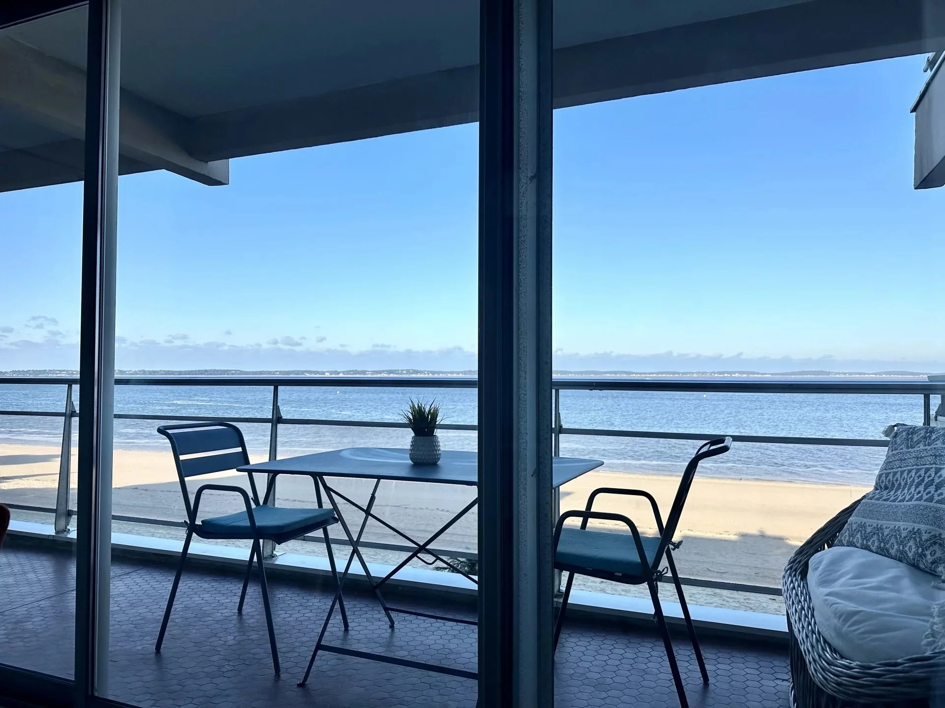 Terrasse avec deux chaises et une table en face de la mer, vue panoramique.