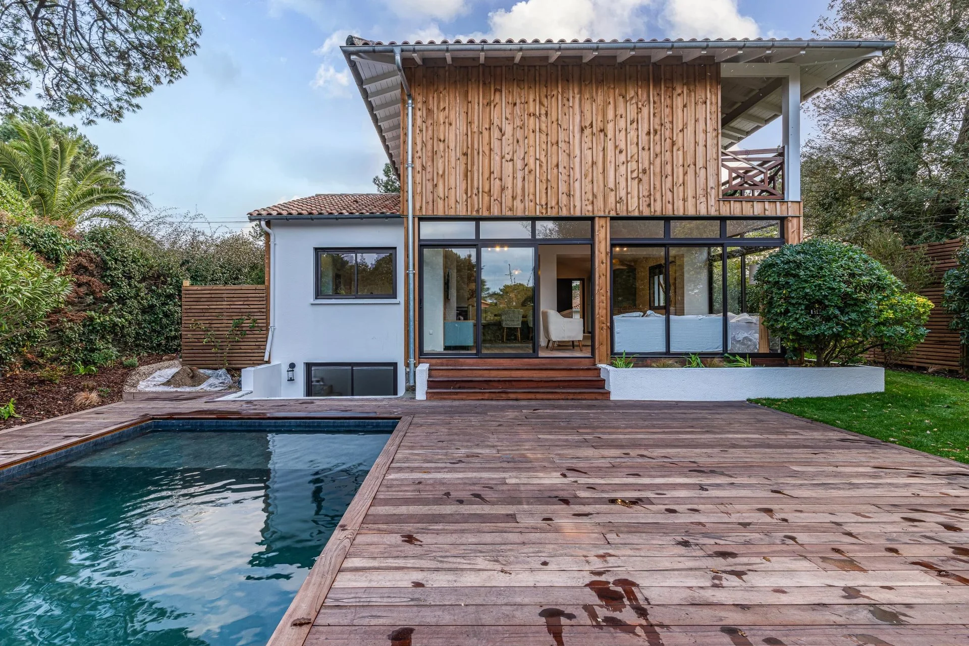 Maison moderne avec piscine, terrasse en bois et jardin