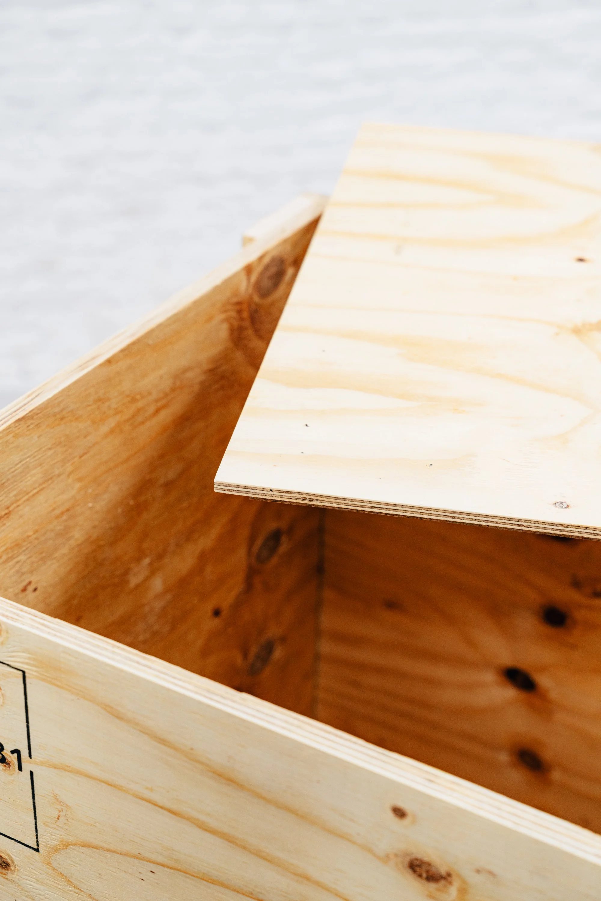 Close-up van het interieur van een op maat gemaakte houten kist met onbewerkte lichtgekleurde houten panelen en zichtbare nerven.Close-up van het interieur van een houten kist met onbewerkte lichtgekleurde houten panelen en zichtbare nerven