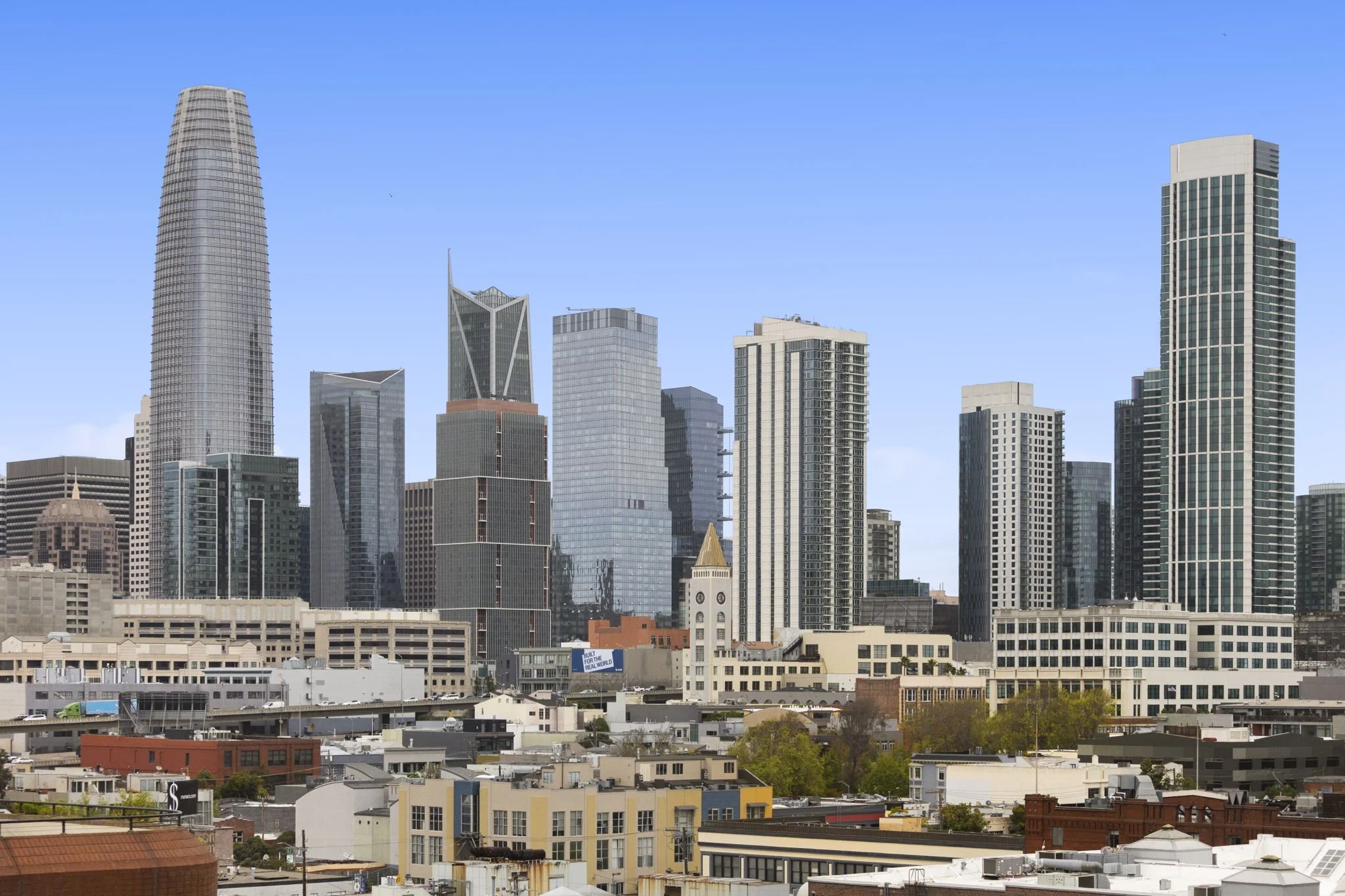 Skyline of downtown San Francisco with various skyscrapers and office buildings under a clear blue sky.