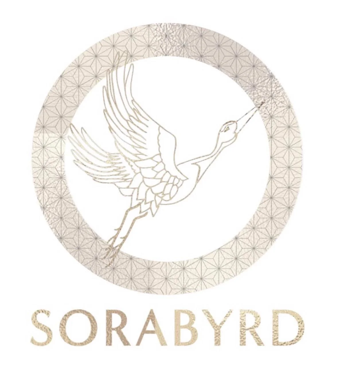 A circular logo featuring a gold outline of a flying heron with outstretched wings inside a patterned border. The word "SORABYRD" is written below in gold capital letters.