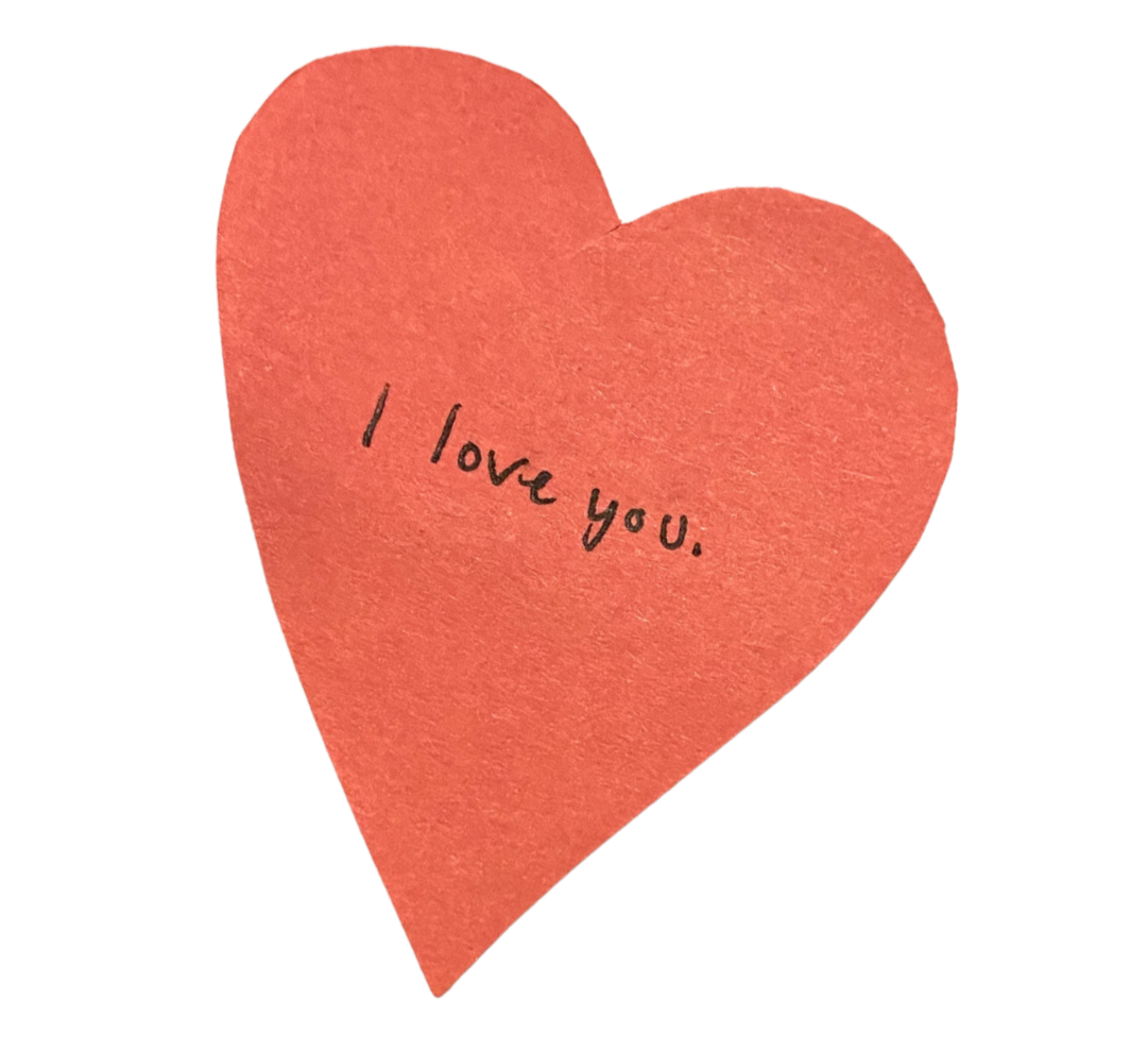 Red paper heart with the words 'I love you.' handwritten on it in black ink.