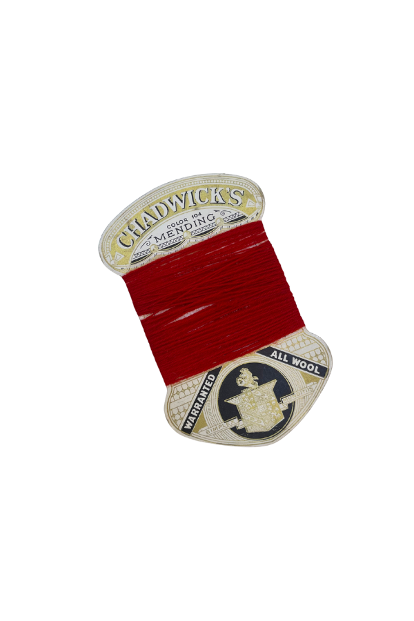 Red sewing thread on a vintage Chadwick's wool thread spool label.