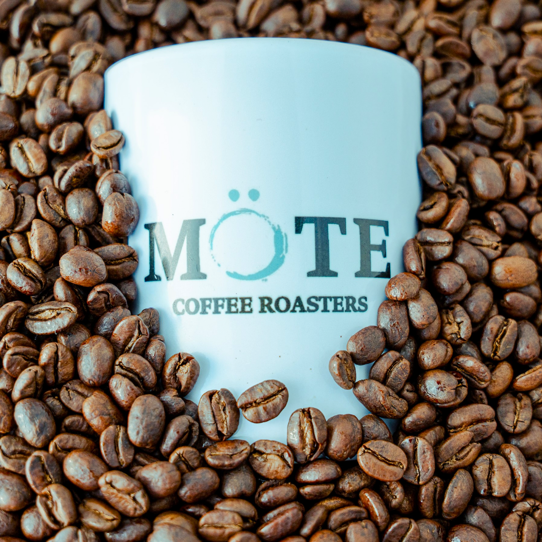 Môte Coffee Roasters mug surrounded by air roasted coffee beans