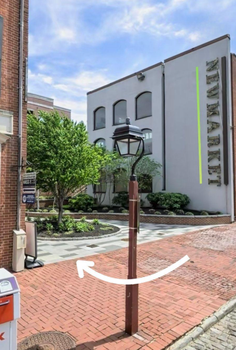 Street scene with a lamp post in the foreground, a brick-paved sidewalk, and a white building with the sign "Make Market" on the side. Vérité Aesthetic Medicine | Injectables in Philadelphia