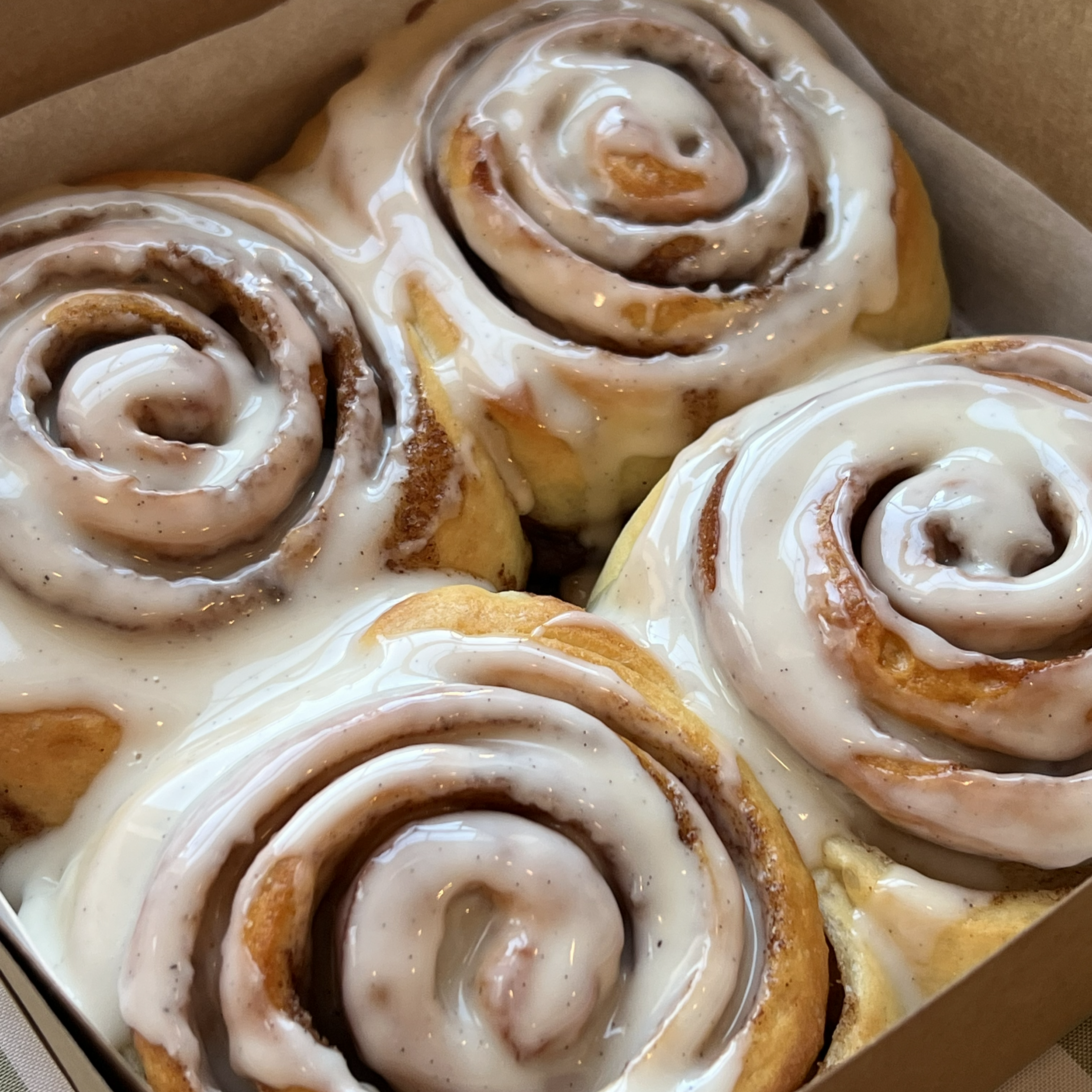 Close-up view of cinnamon rolls topped with maple glaze. 
