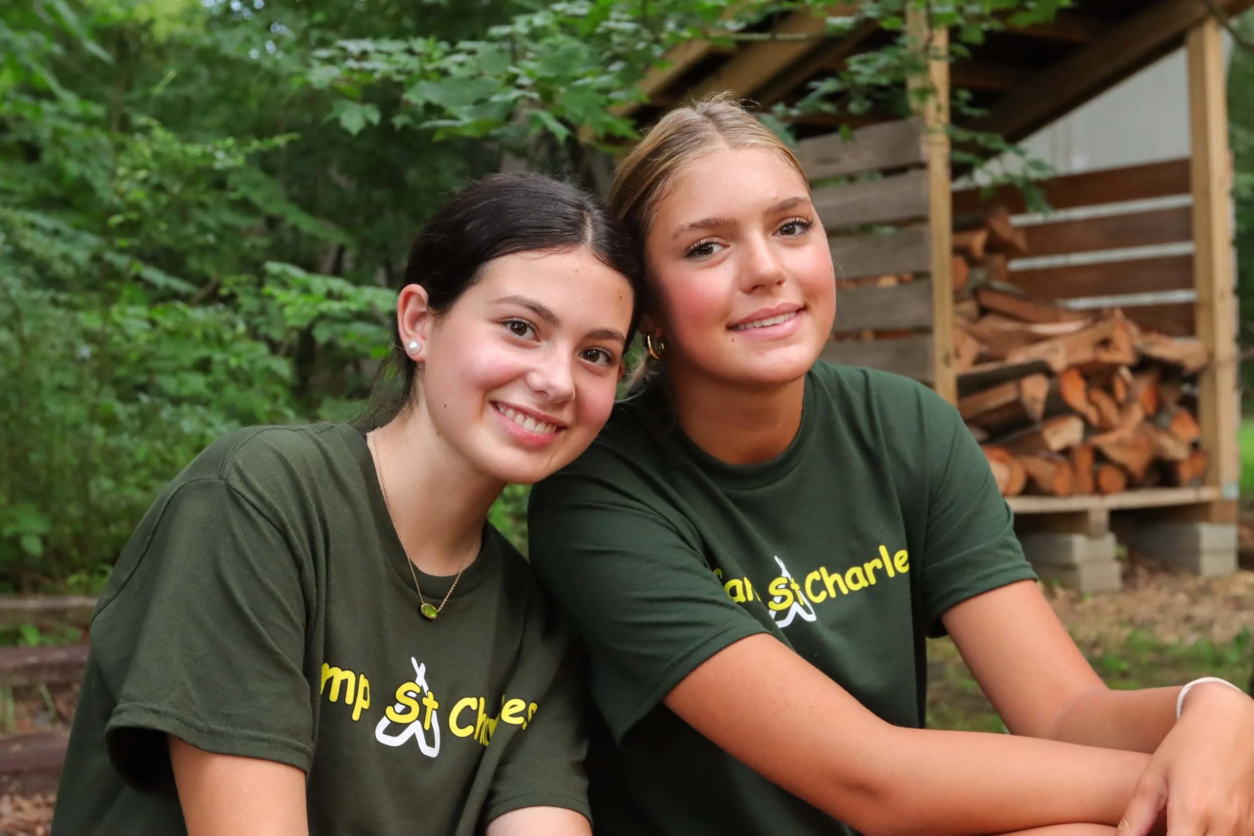 Two girl mentor campers sitting and smiling.
