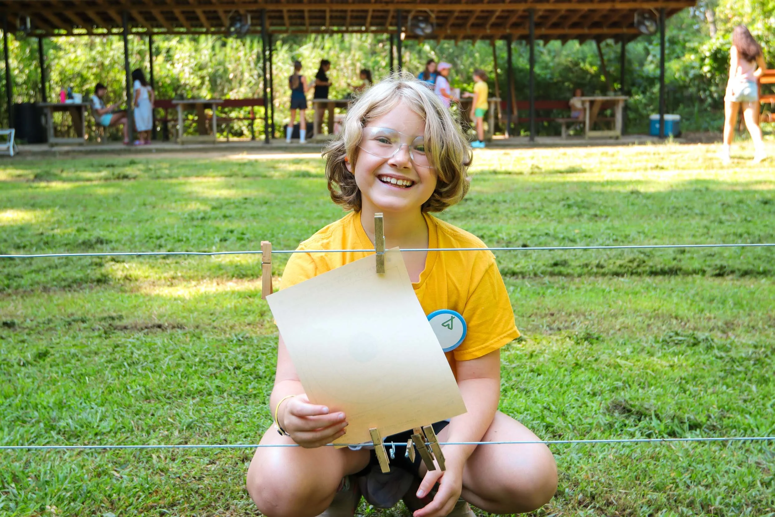 A young girl holds her riflery bullseye target.