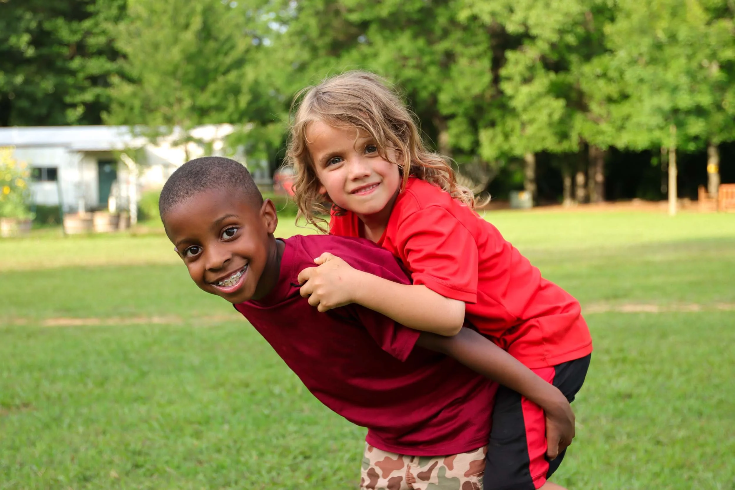 A boy giving another boy a piggyback ride.
