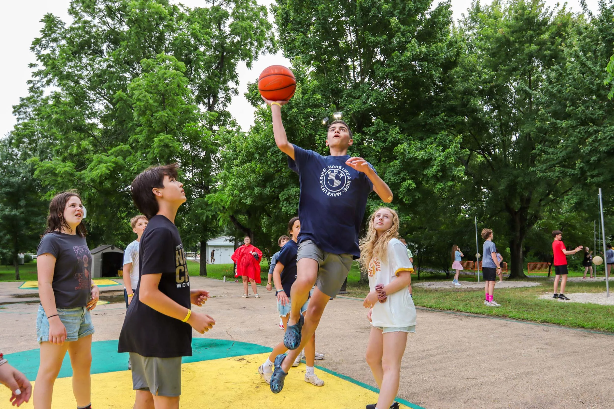 Campers playing basketball outdoors.