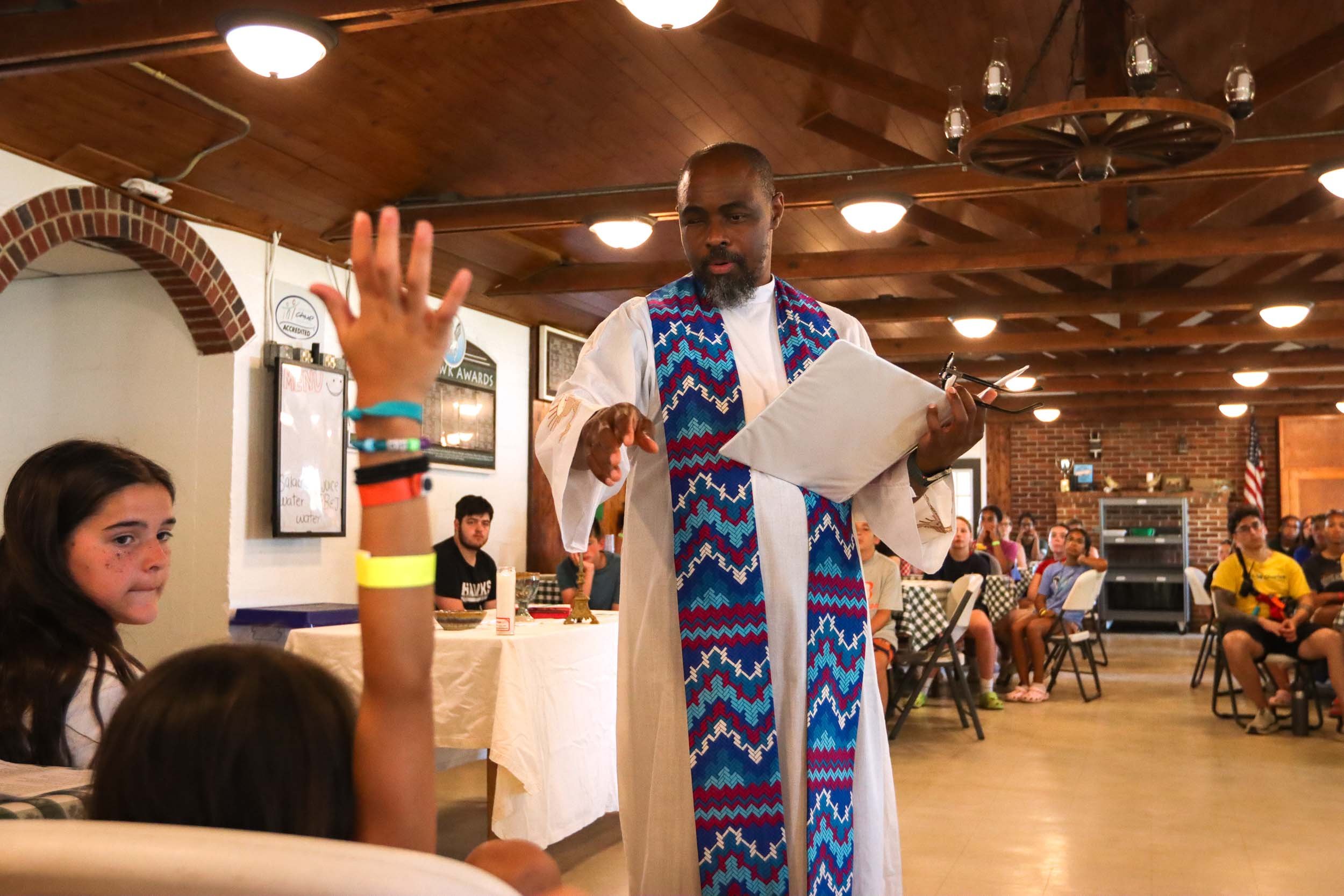 A Catholic priest speaking to campers at all camp Mass.