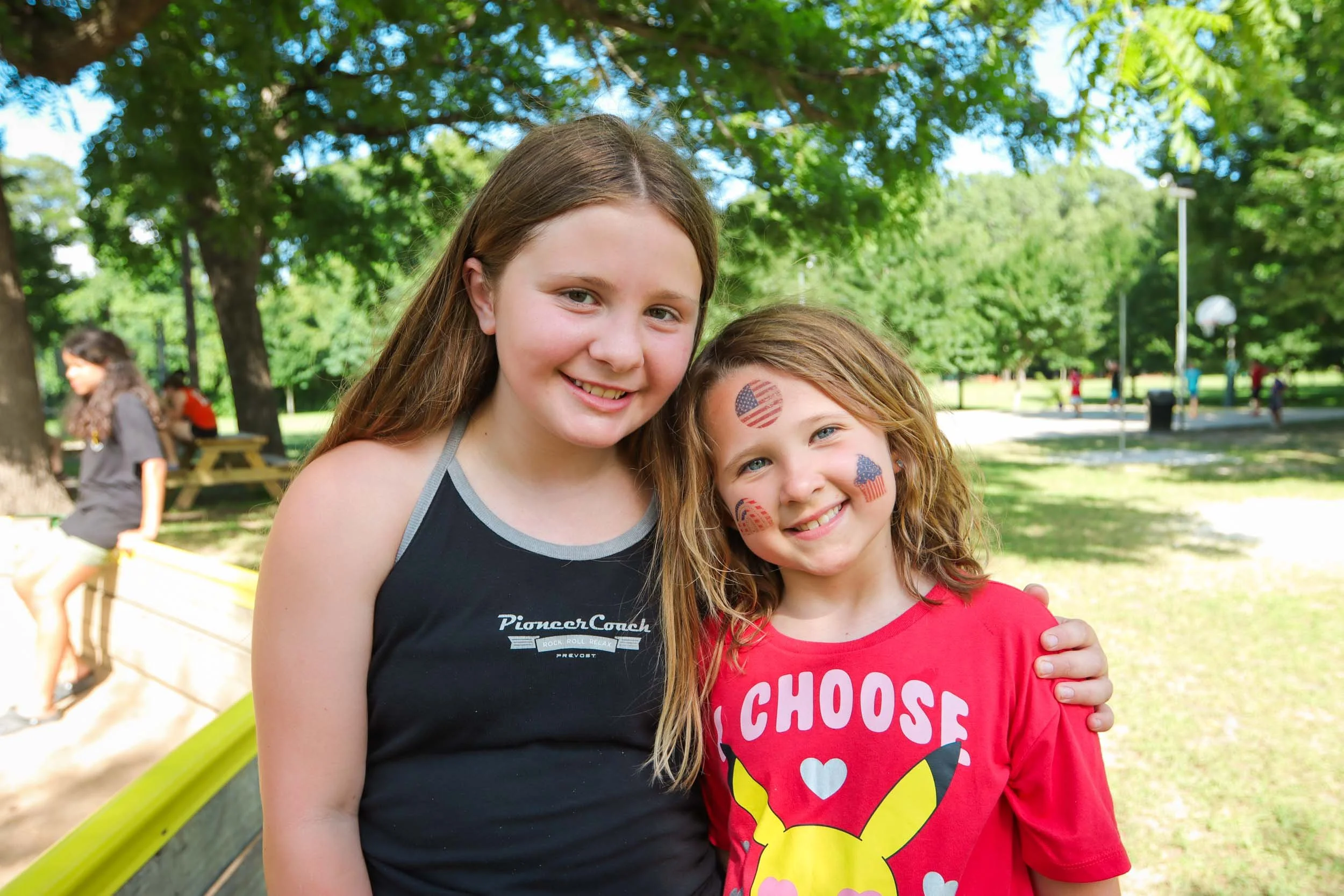 Two smiling girls wearing face paint of American flags.