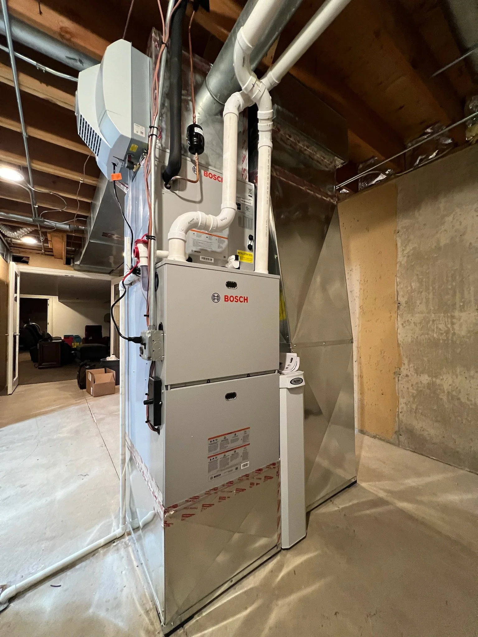 HVAC system with ductwork, pipes, and equipment in a basement or utility room.