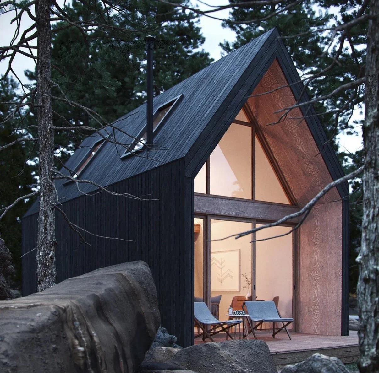 A modern A-frame cabin with black and wood exterior, large glass windows, and a balcony with chairs, situated in a wooded area.