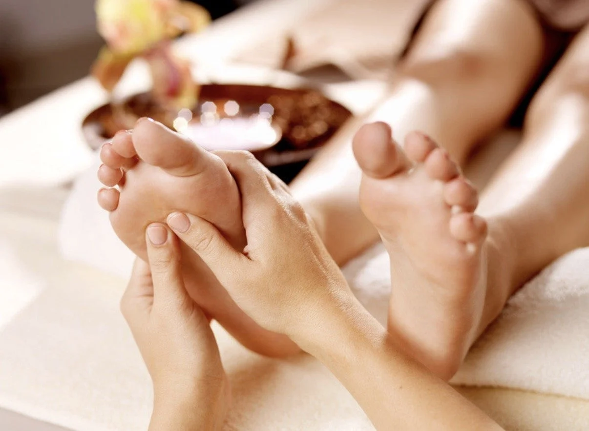 Person receiving a foot massage in a spa setting.