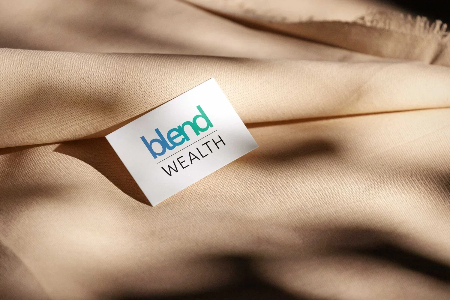 Close-up of a beige fabric with a white label that says 'blendl WEALTH' in colorful and black text.