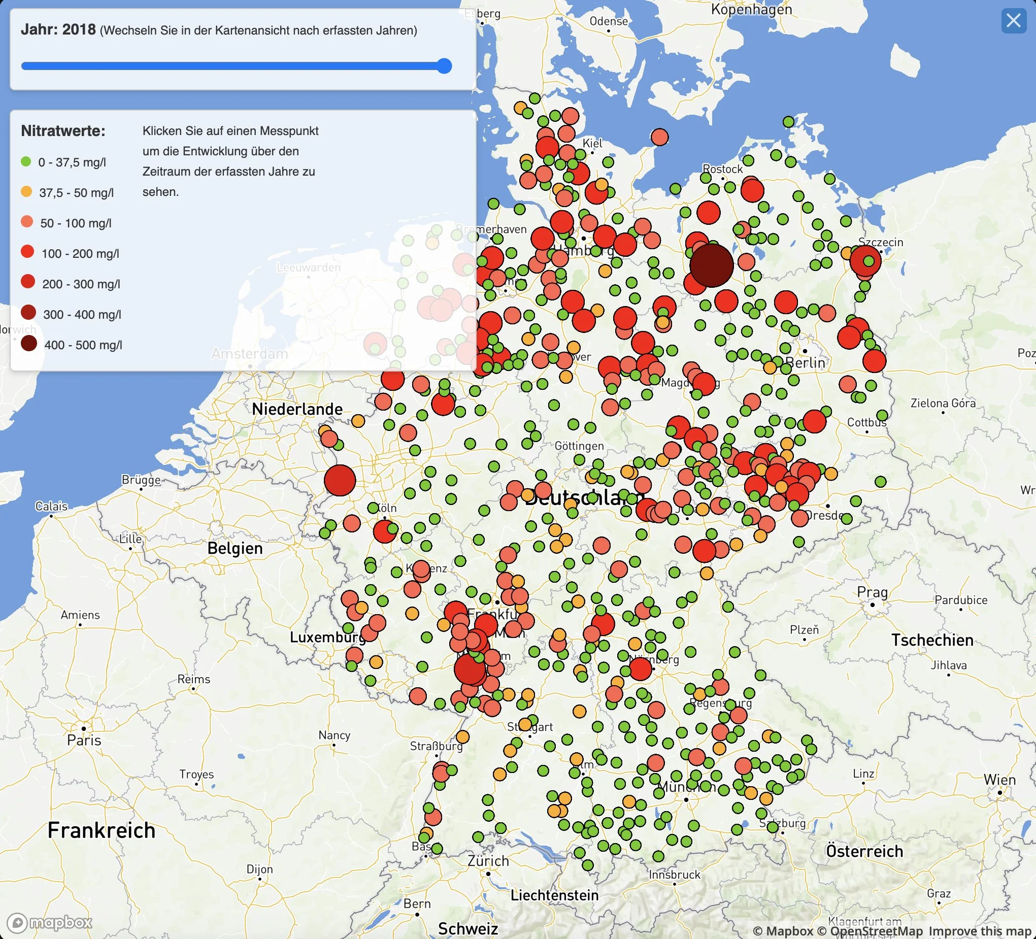 Karte der Nitratwerte in Deutschland im Jahr 2018, farblich gekennzeichnet von grün bis dunkelrot, mit größeren Kreisen in verschiedenen Regionen, die Nitratkonzentrationen anzeigen.