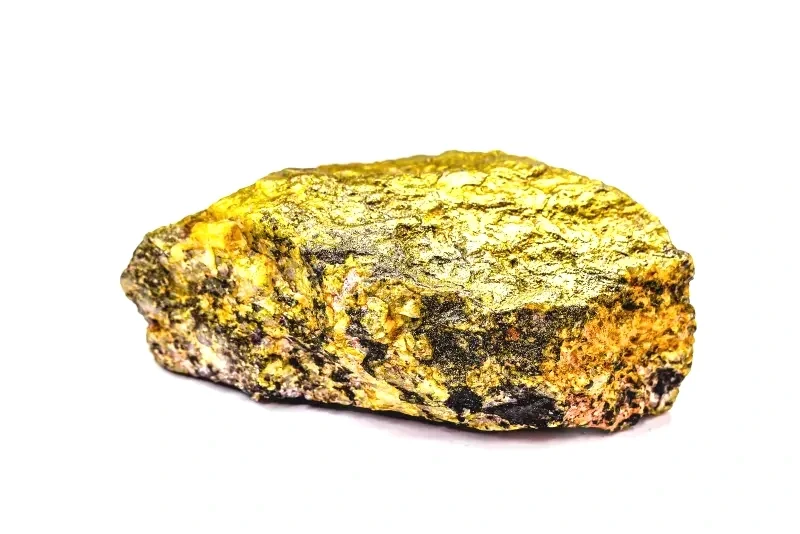Ein goldfarbener, unregelmäßig geformter Stein auf weißem Hintergrund.