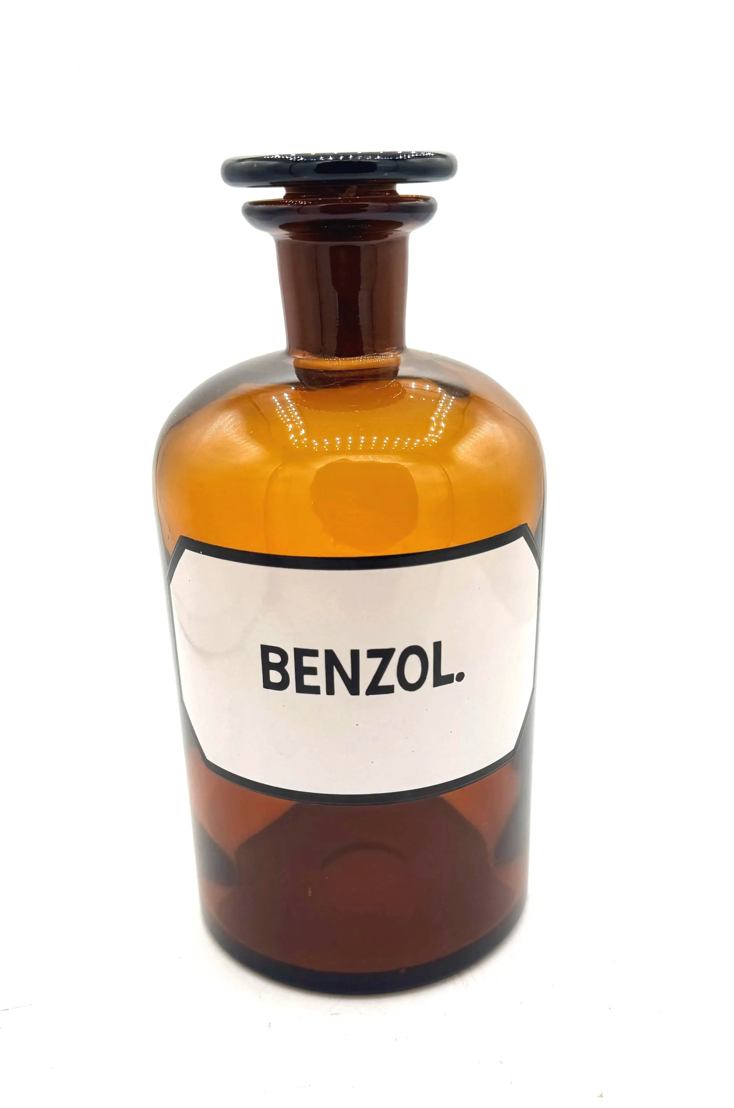 Eine braune Glasflasche mit einem weißen Etikett, auf dem das Wort 'BENZOL' steht.