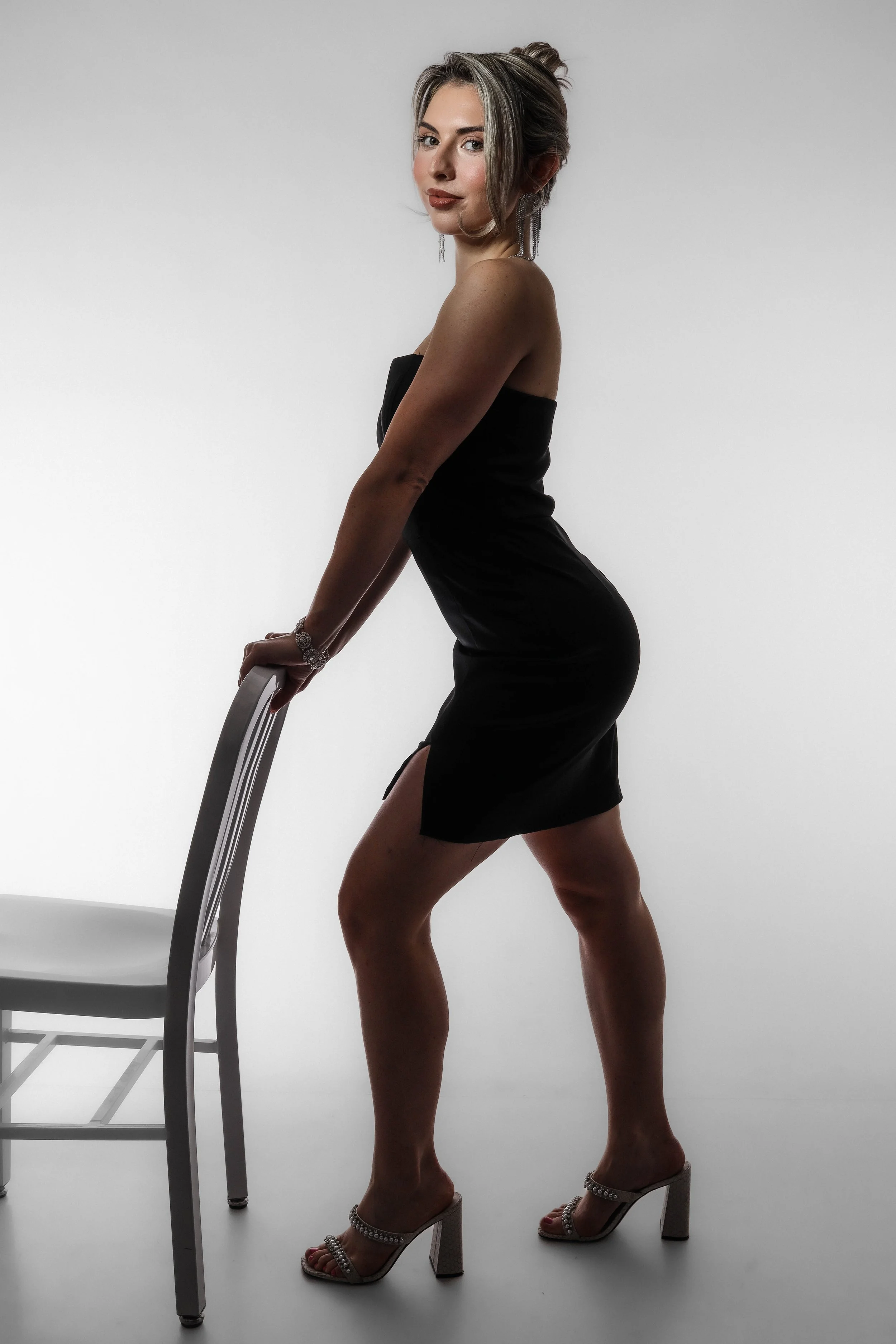 Valerie Black Dress - holding chair (both arms).jpg