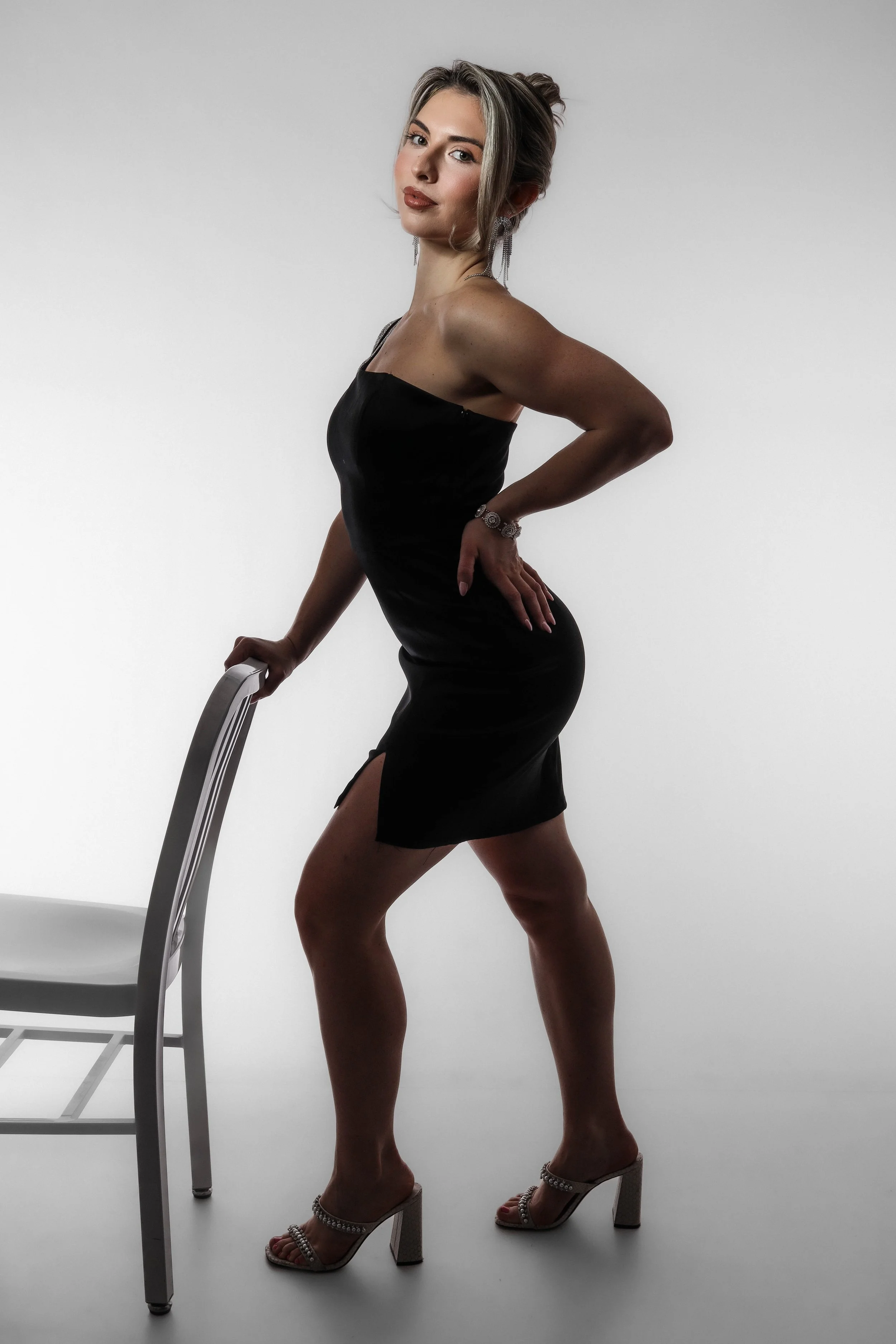 Valerie Black Dress - (holding chair, one arm up).jpg