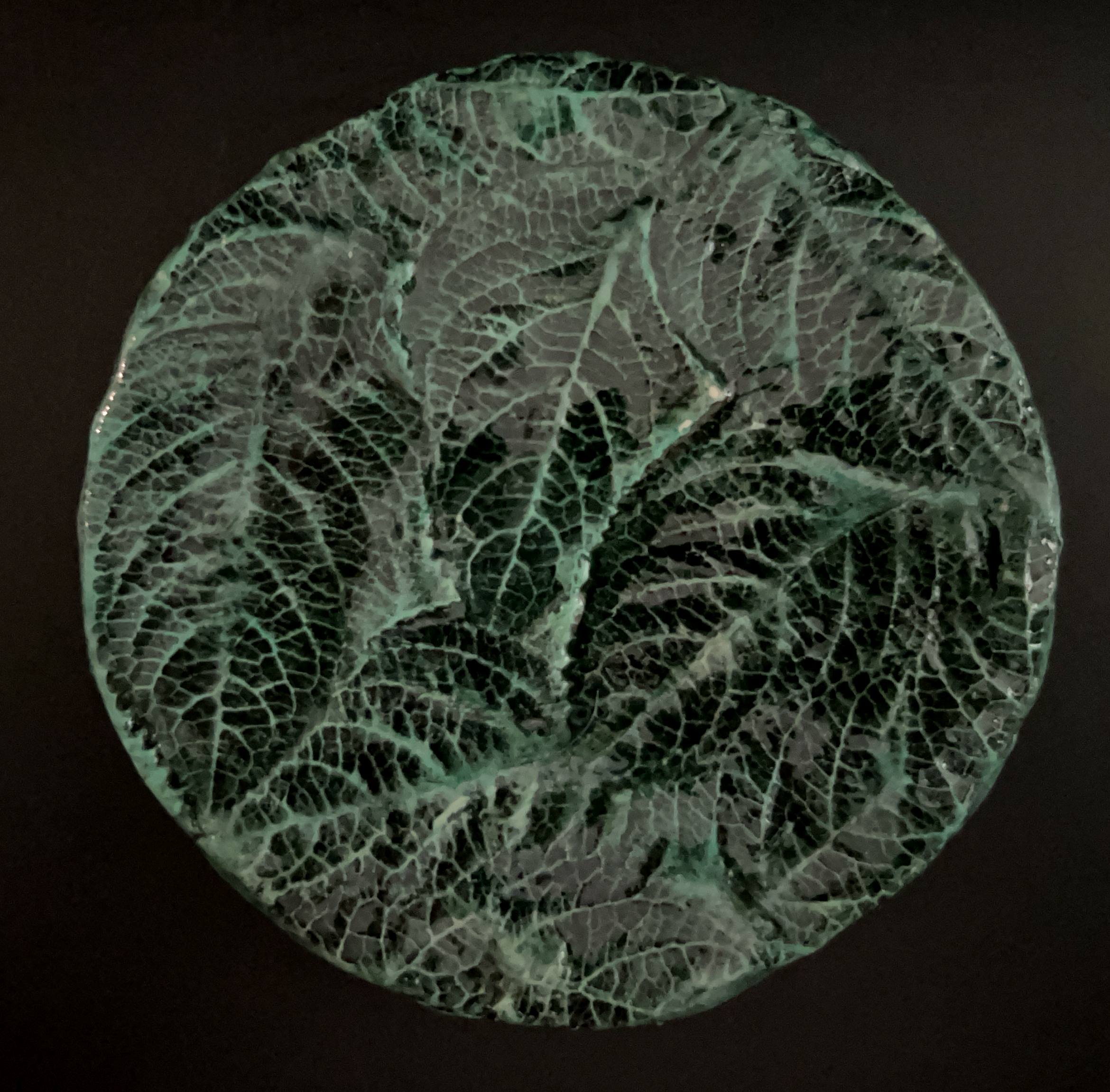 Close-up of a decorative glass plate with a leaf pattern design.