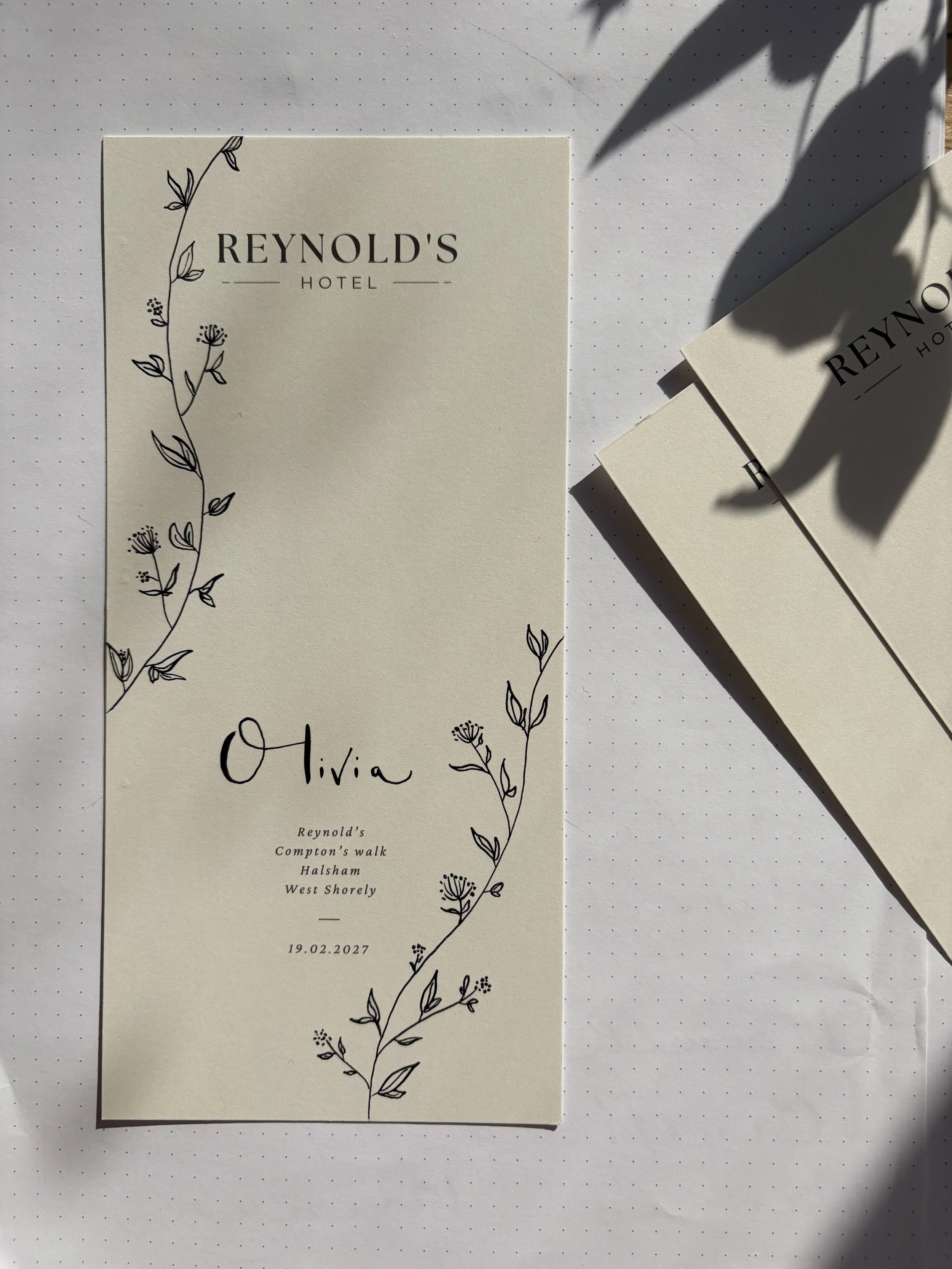 A menu hand embellished with floral illustrations, includes the names Olivia and the date 19.02.2027.