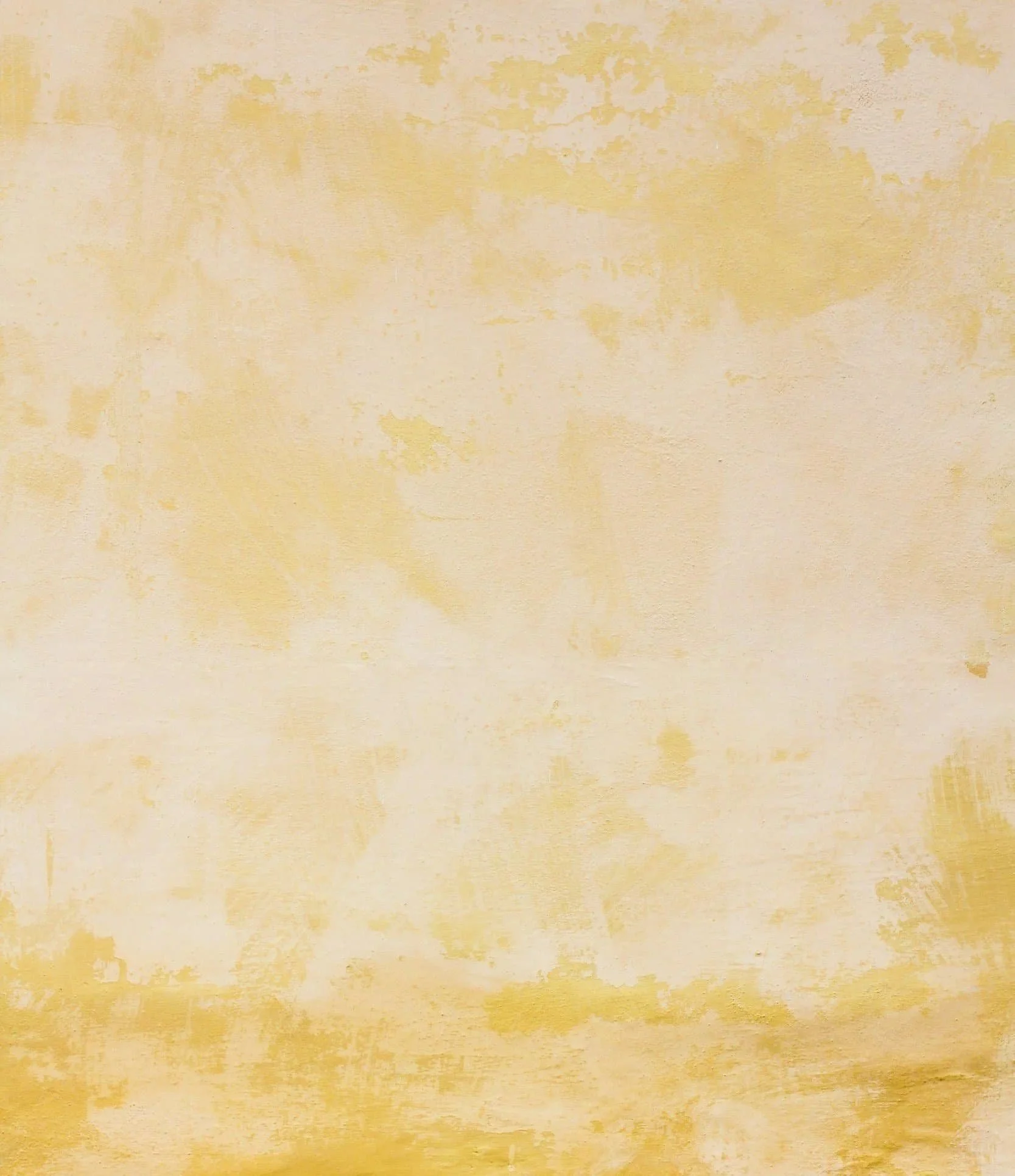 A textured wall with a warm, yellowish tone and an uneven, mottled surface.