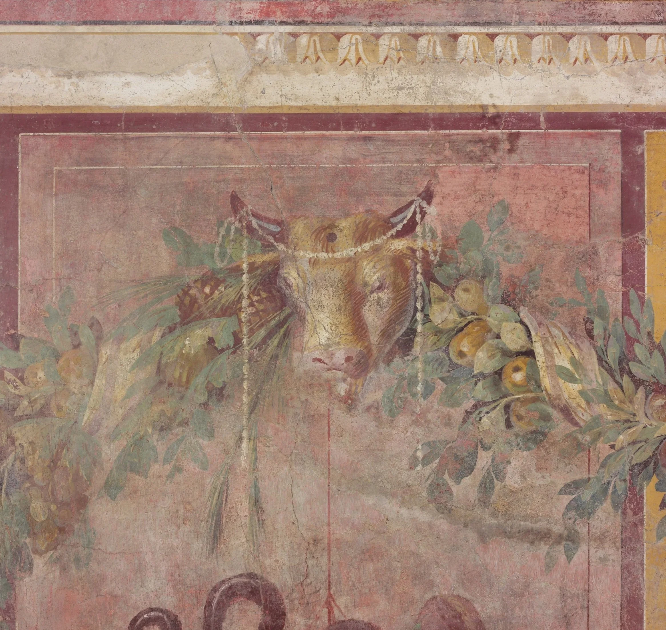 Ancient wall mural with floral and geometric designs, showing signs of age and fading.