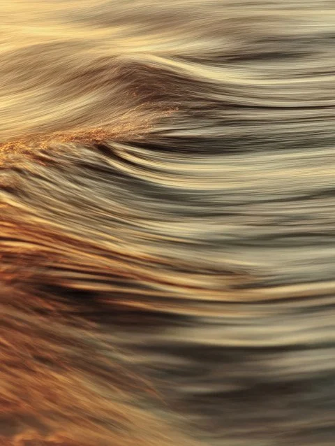 Close-up of swirling water with warm tones.