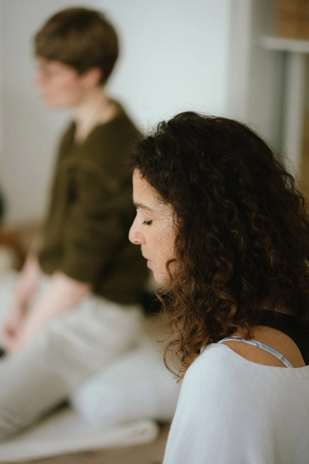 Saskia Schreiber im seitlichen Profil in einer bedächtigen Ausbildungssituation während ihrer Yin Yoga Ausbildung.