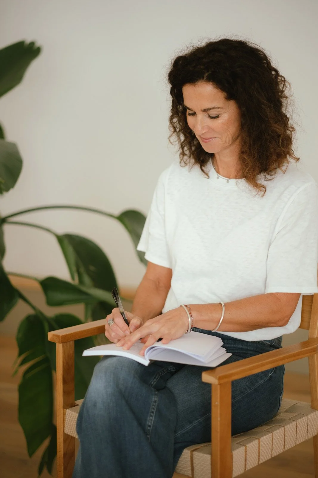 Saskia Schreiber macht mit einem sanften Lächeln Notizen – als Bild im Rahmen einer therapeutischen EInzelbegleitung.