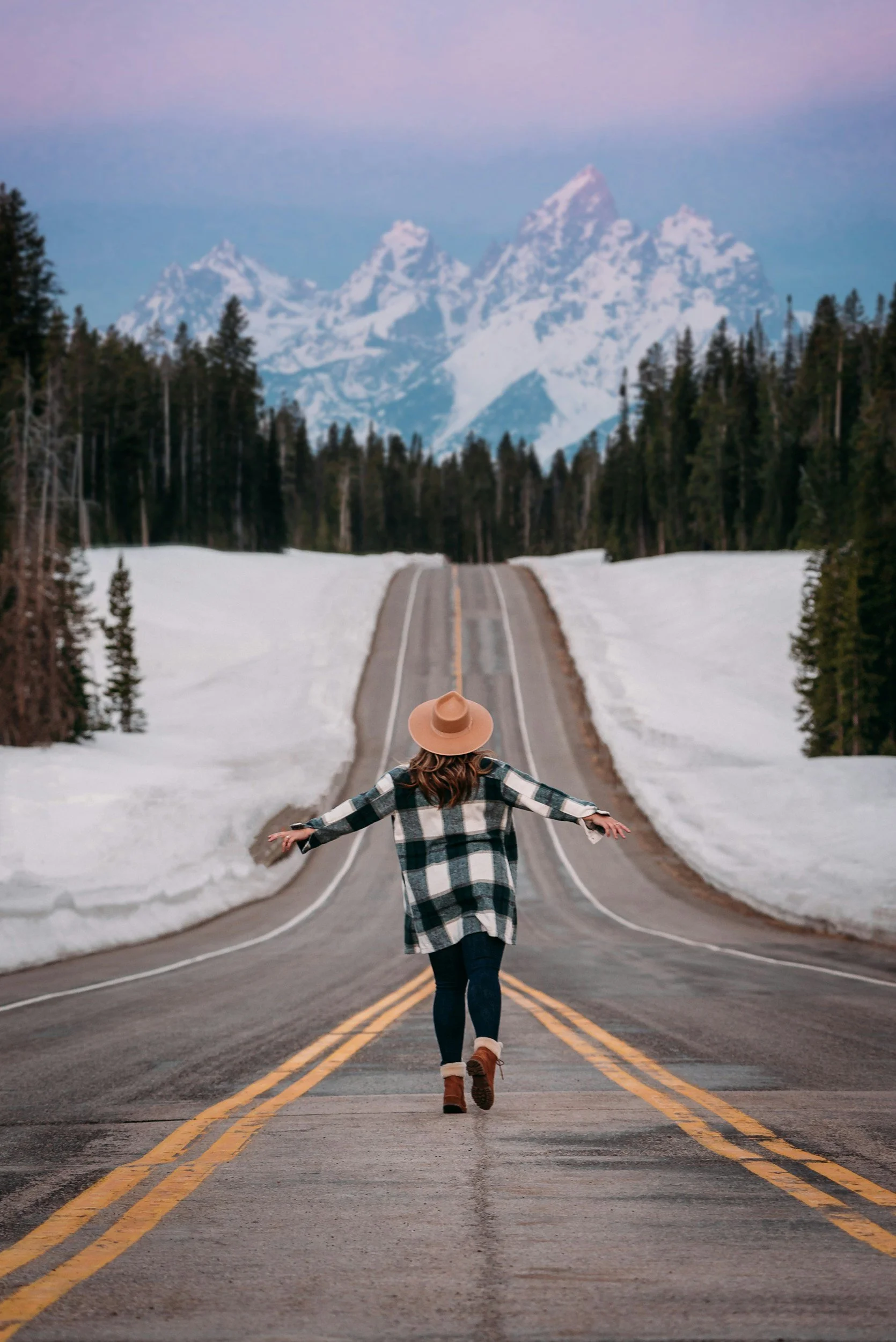 A woman walking down the middle of a long road, as if her executive coaching or workshops with Cambio Leadership have put her on a good path.