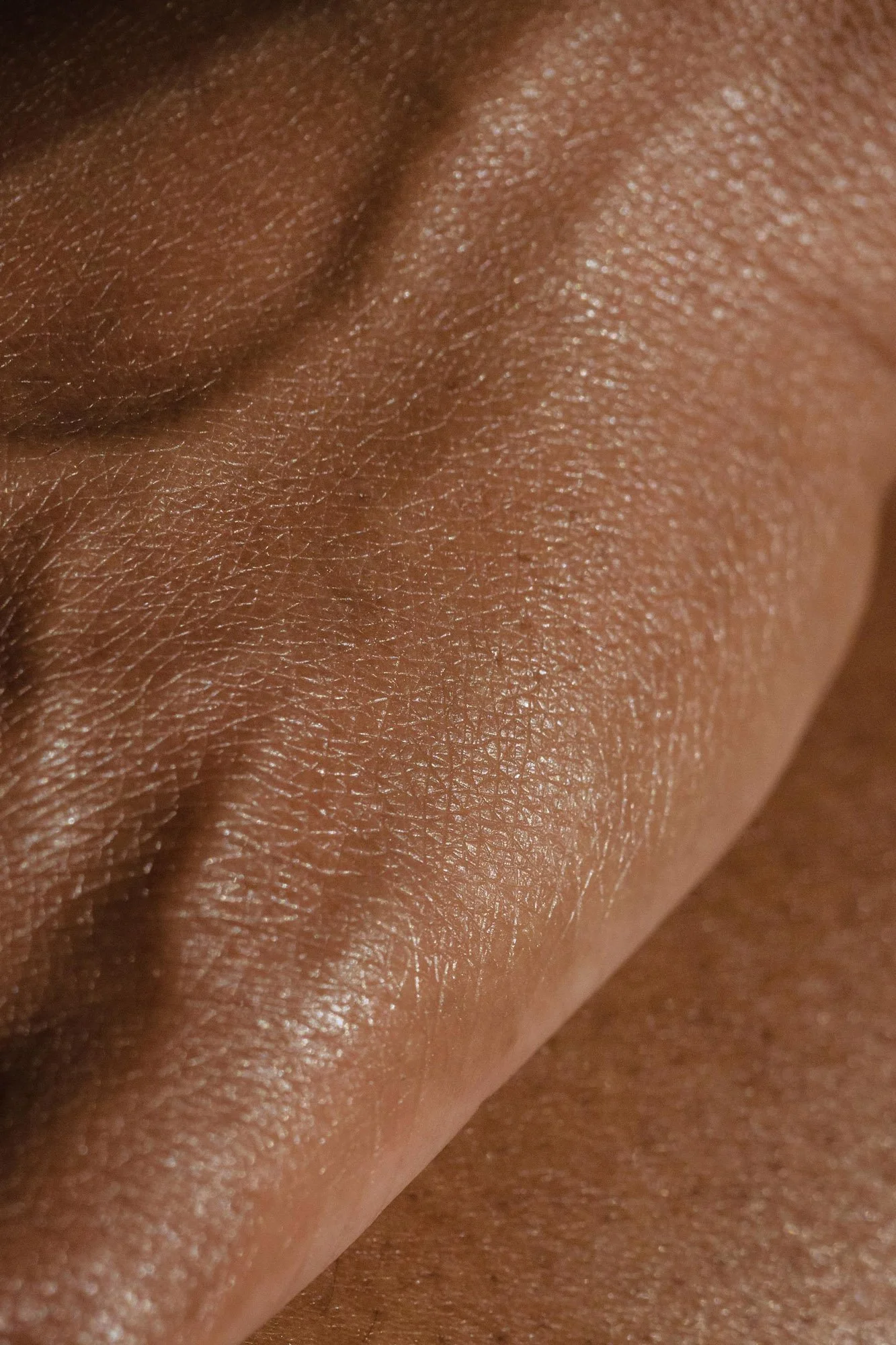 Zoomed-in image of human skin with detailed texture and fine hair.