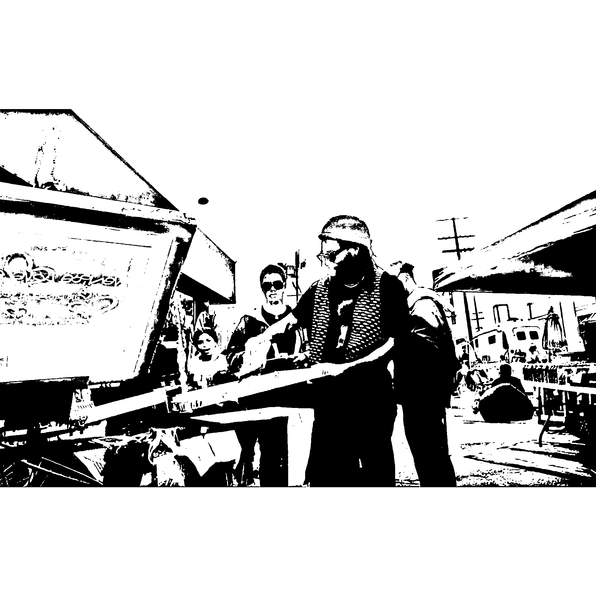 Black and white image of three people walking outdoors, wearing sunglasses and casual clothing, with a building and utility poles in the background.