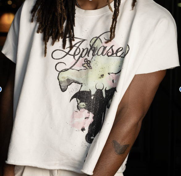 Close-up of a person wearing a white T-shirt with a graphic design of a cow's head and the word "Apose" written above it.
