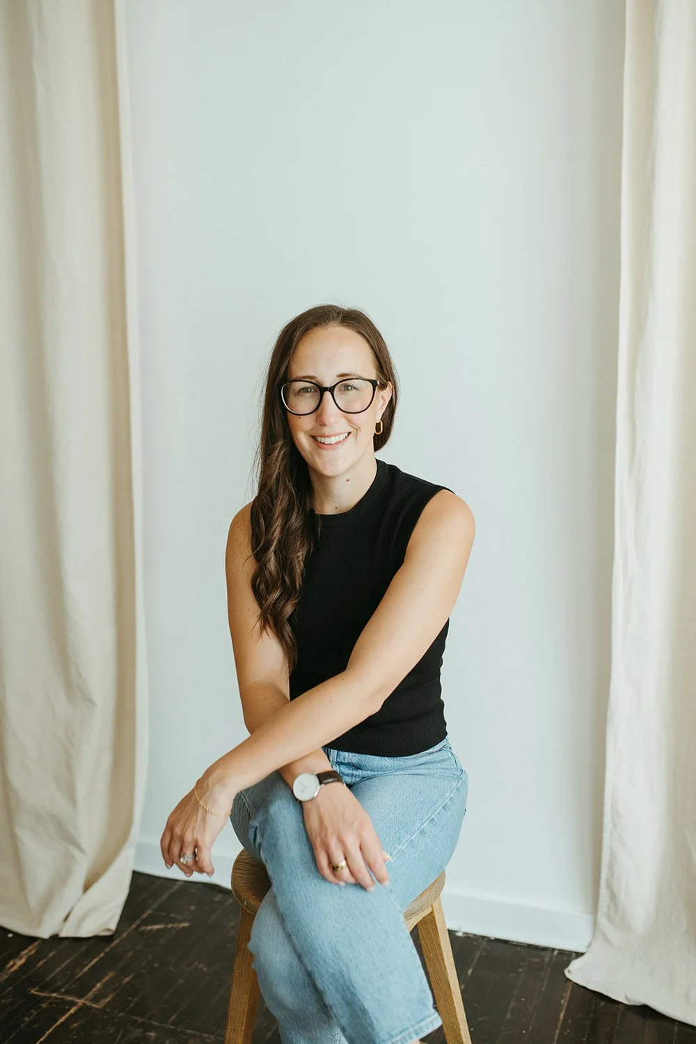 Michelle Arnason sitting on a stool, smiling warmly