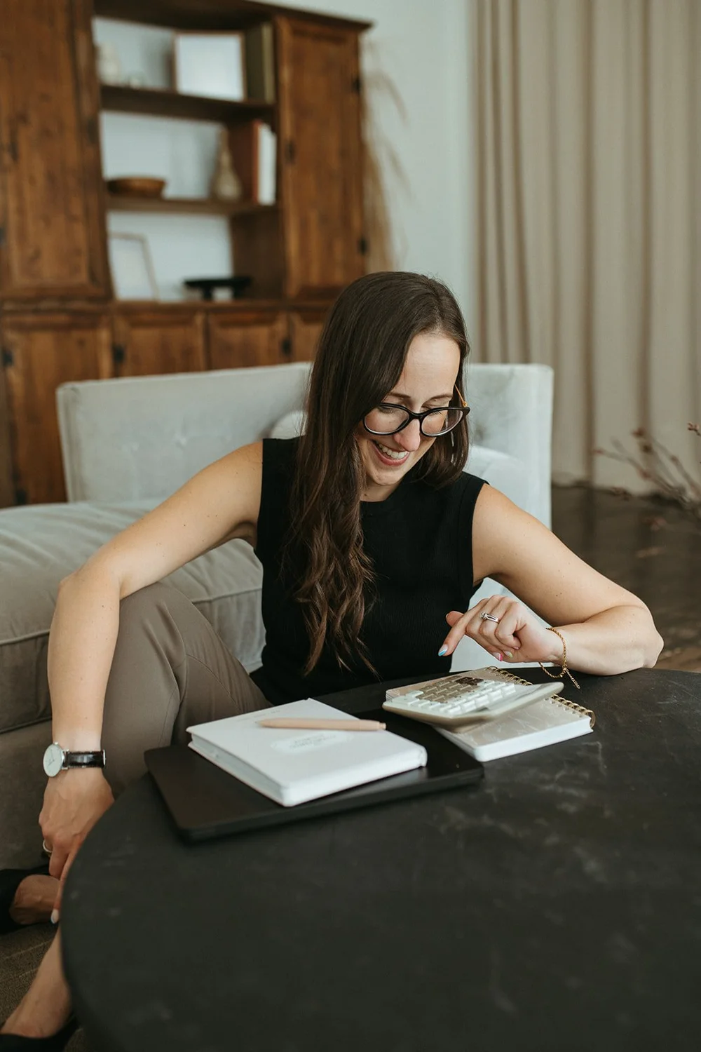 Michelle Arnason at a desk with a calculator and notebooks, smiling