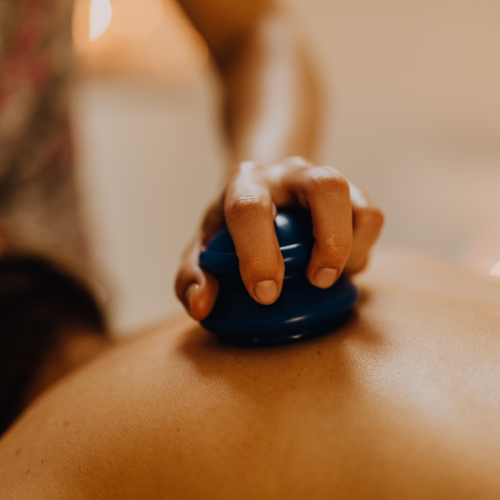 Person receiving a cupping massage with a massage cup on their back