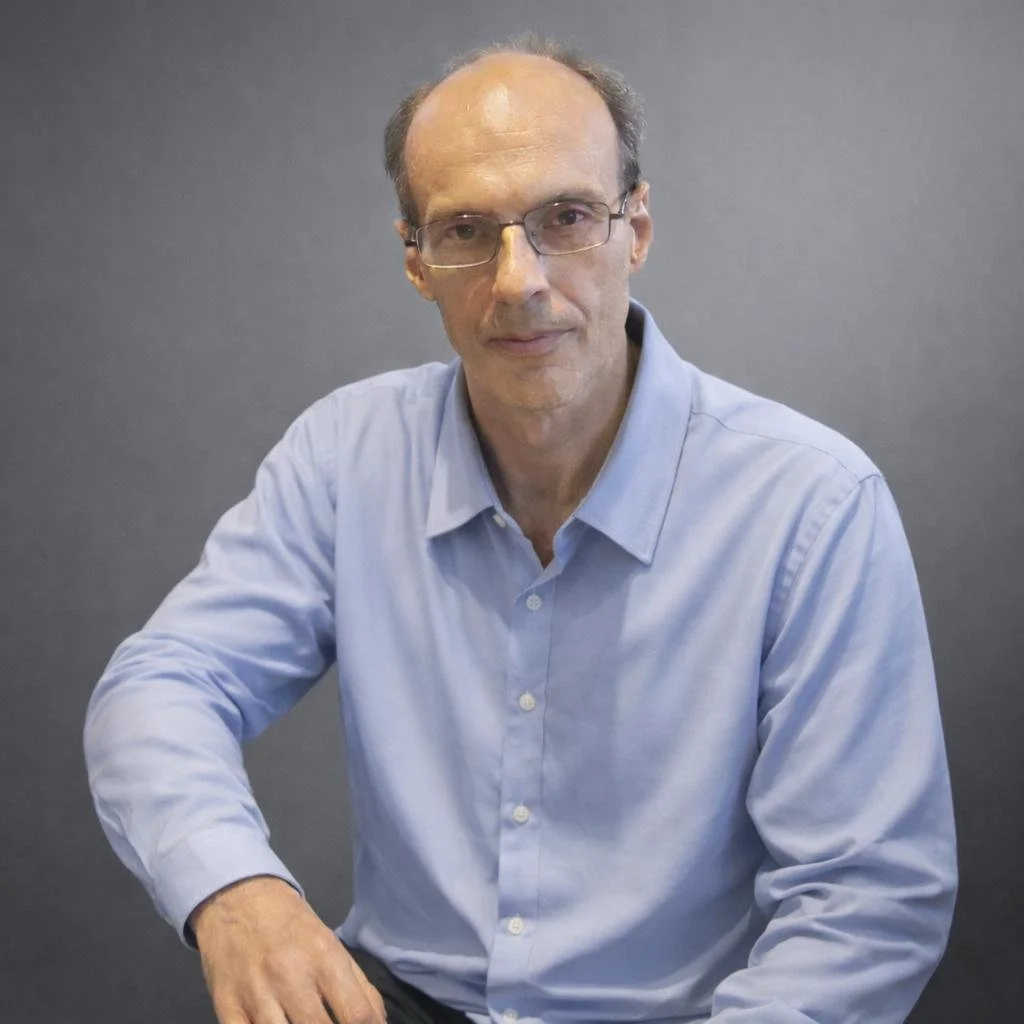 Olivier, profesor nativo de francés con décadas de experiencia académica, sonriendo y listo para impartir clases de idiomas online.