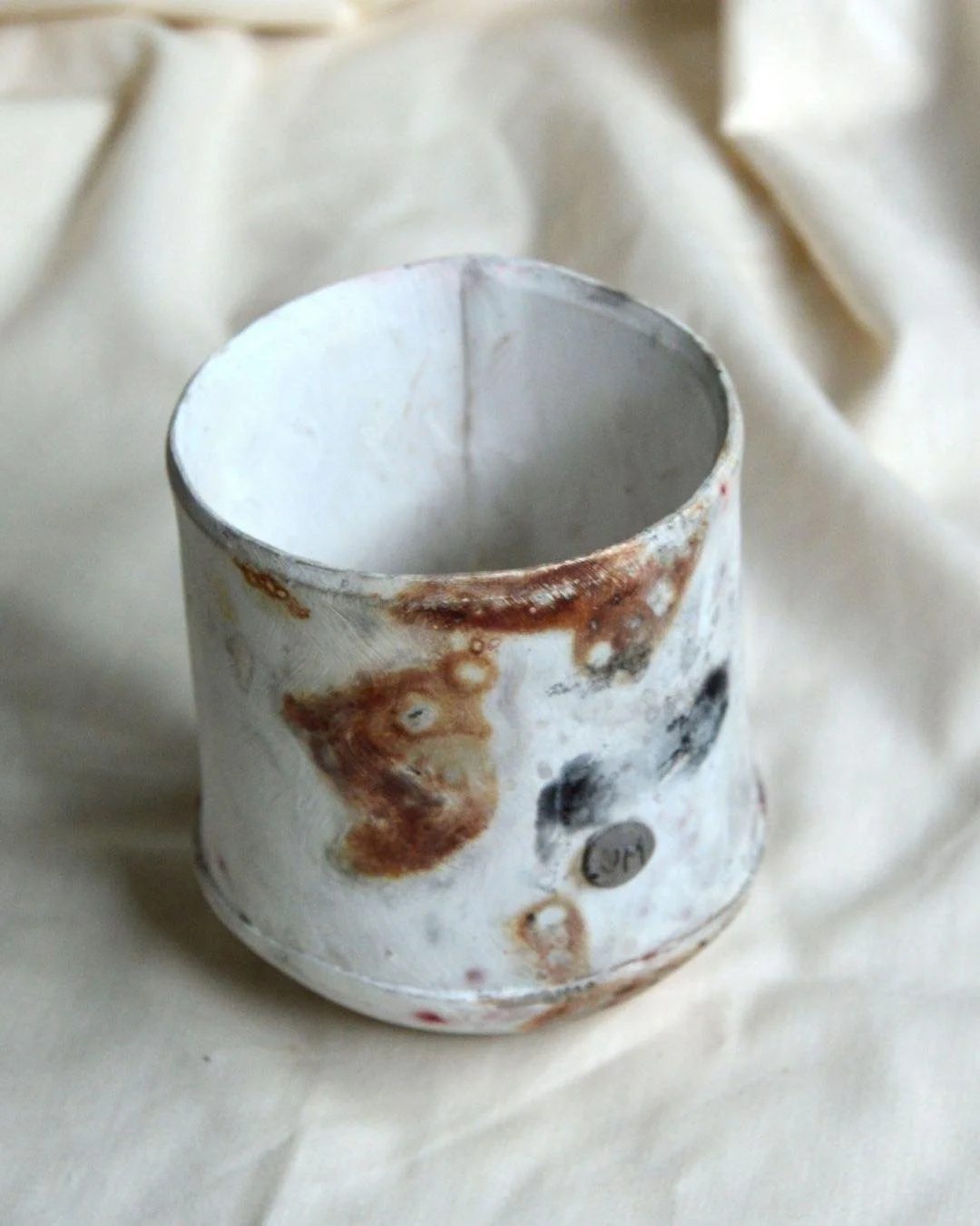 Mottled markings of iron turnings and oxides. I love this slab cup form and can&rsquo;t wait to return to making it ☕️
.
.
.
.
.
.
#pottery #ceramicmug #slabbuiltceramics #saggarfired #smokefiring #handcrafted #ceramicdesign #potterylife #modernceram